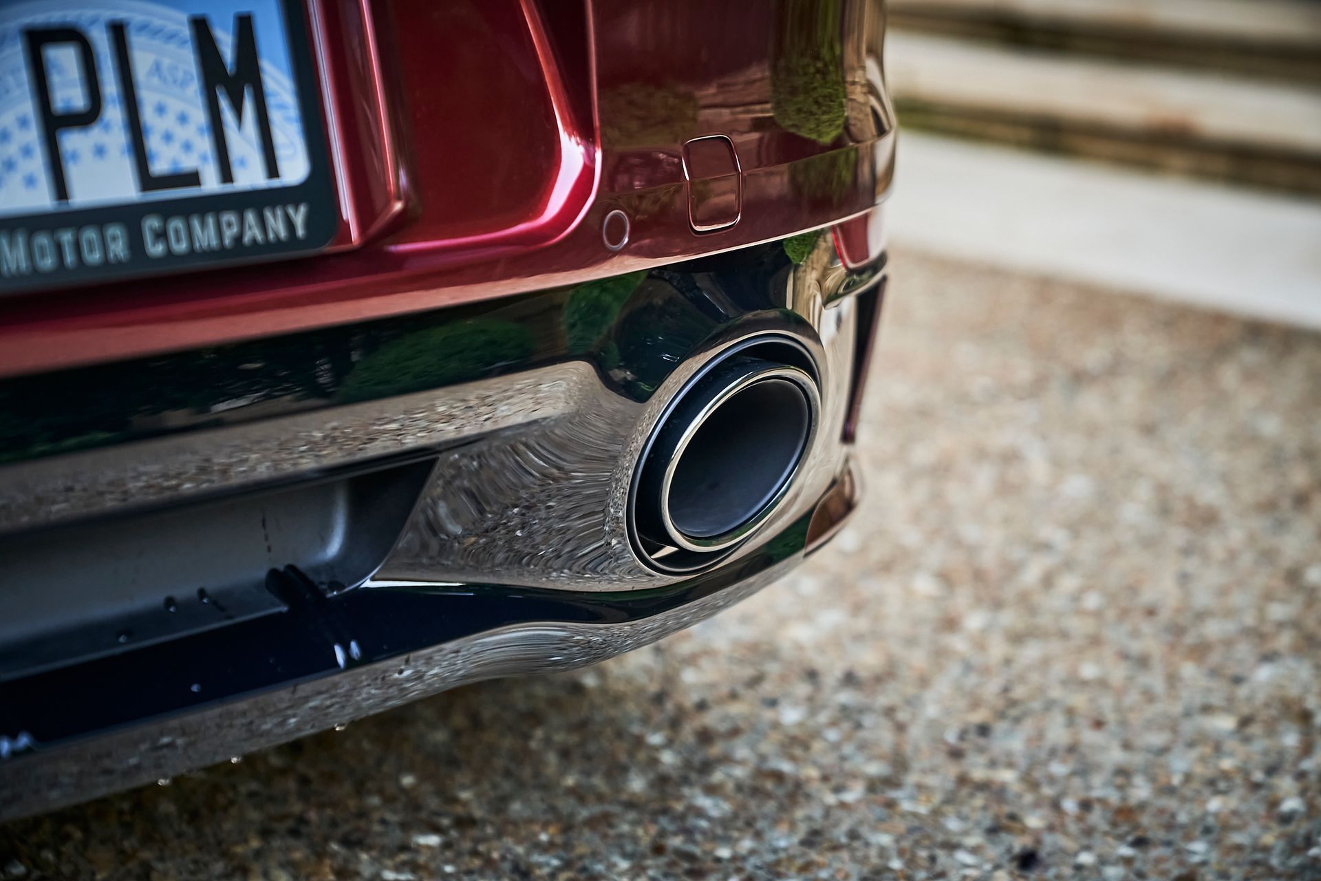 A close up of the exhaust pipe of a red car.
