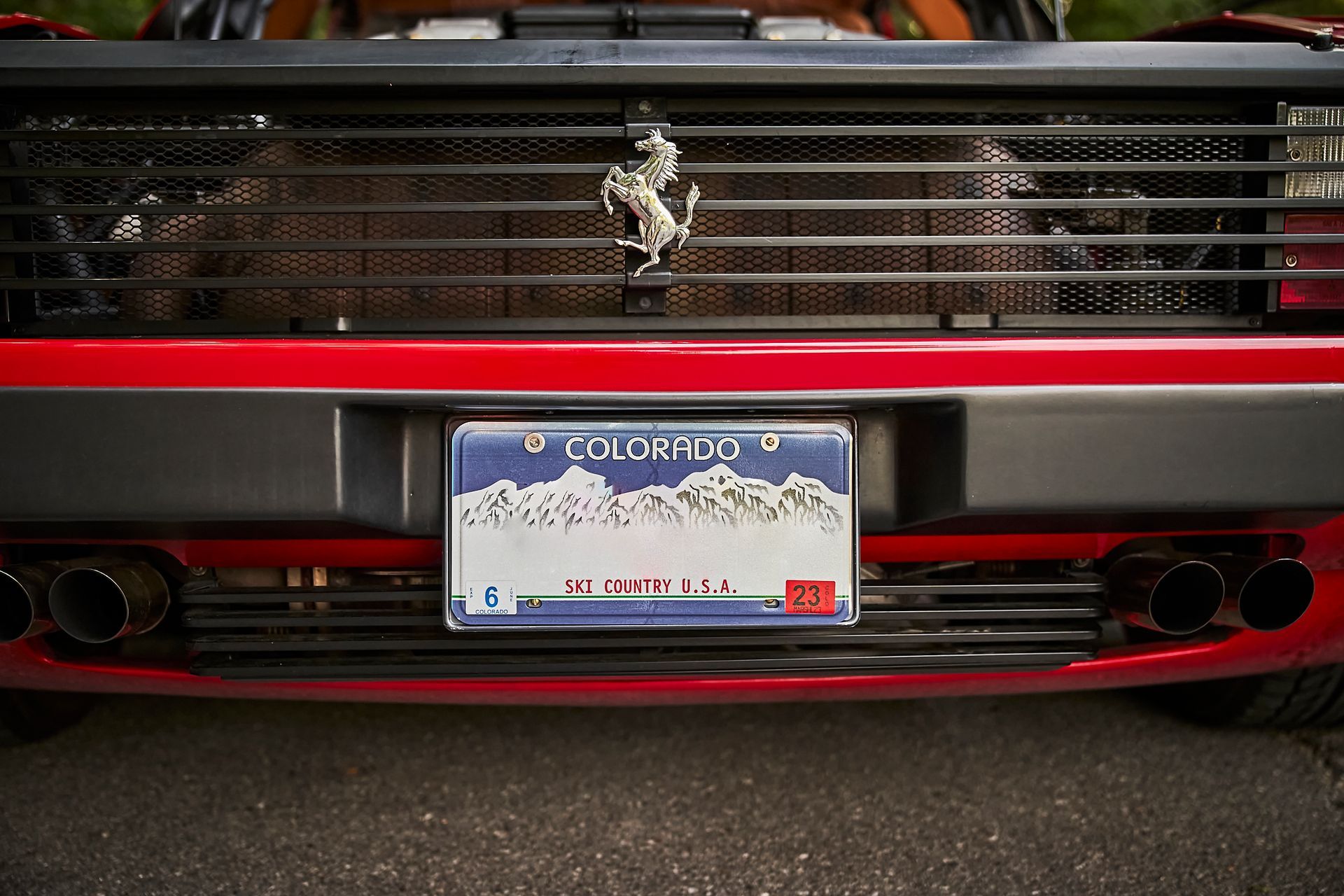A red ferrari with a license plate from colorado