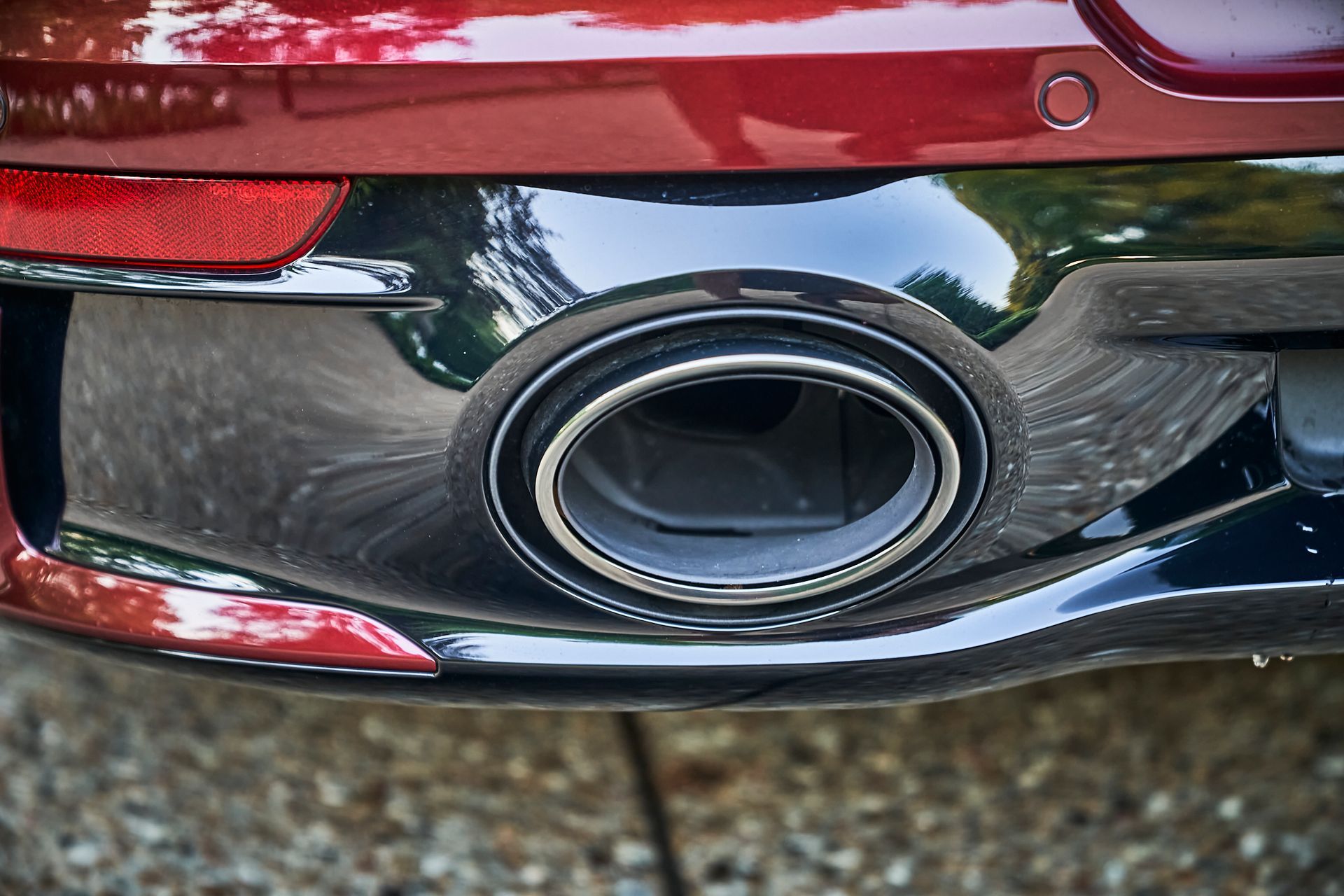 A close up of the exhaust pipe of a red car.