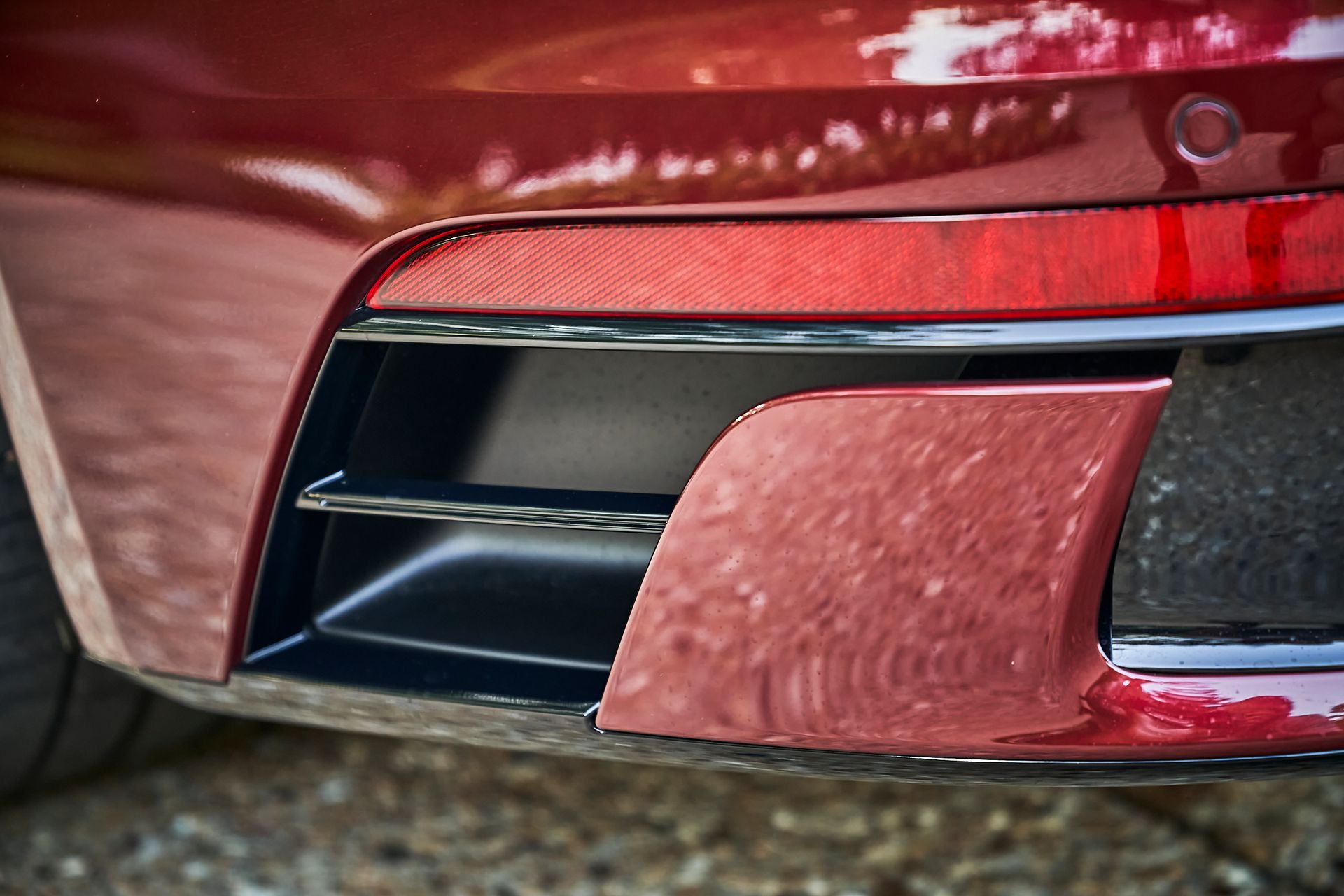 A close up of the front bumper of a red car.