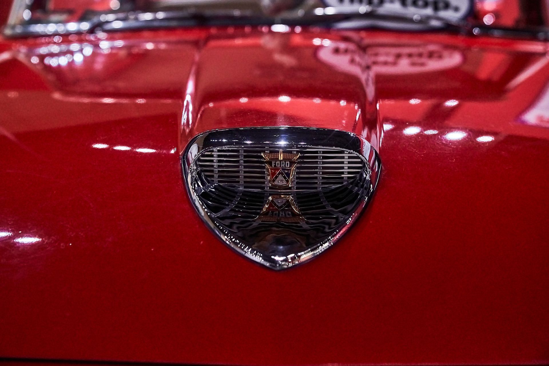 A close up of the hood of a red car.