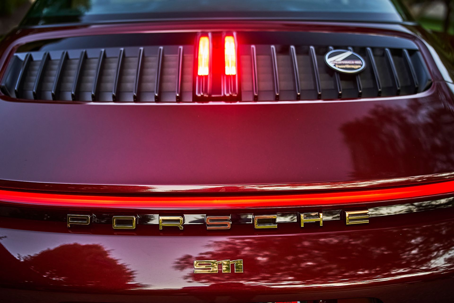 The rear end of a red porsche with the lights on