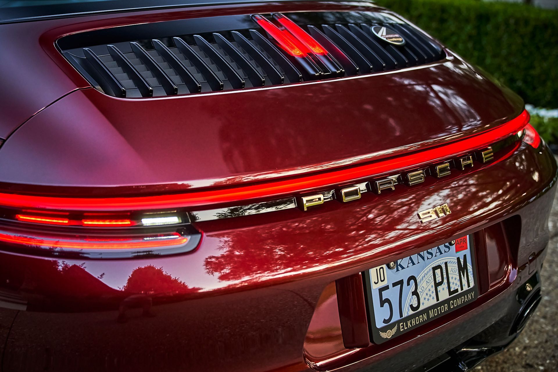 A red porsche with a license plate that says 573 plm