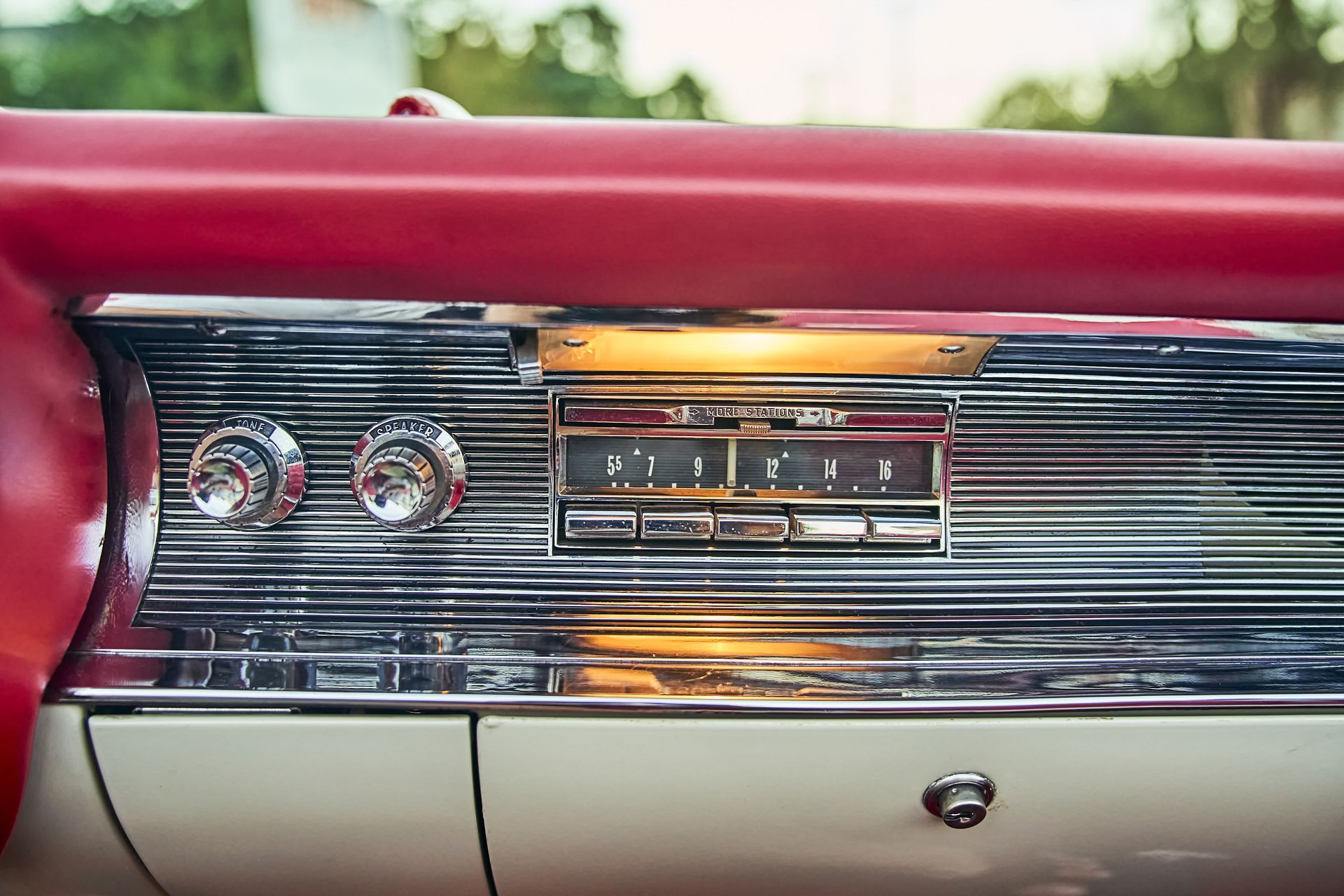A close up of the dashboard of an old red car.
