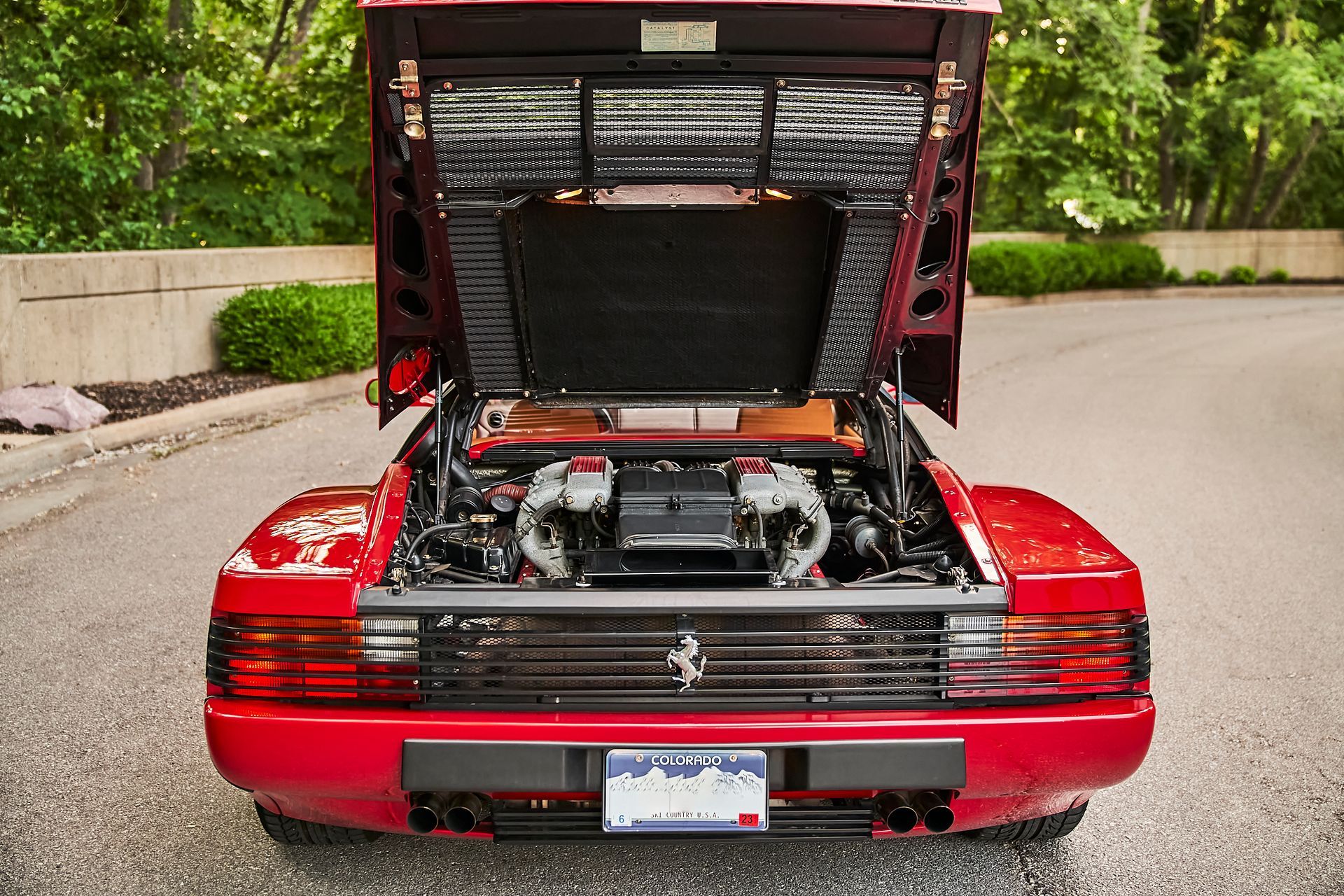 The hood of a red ferrari sports car is open.