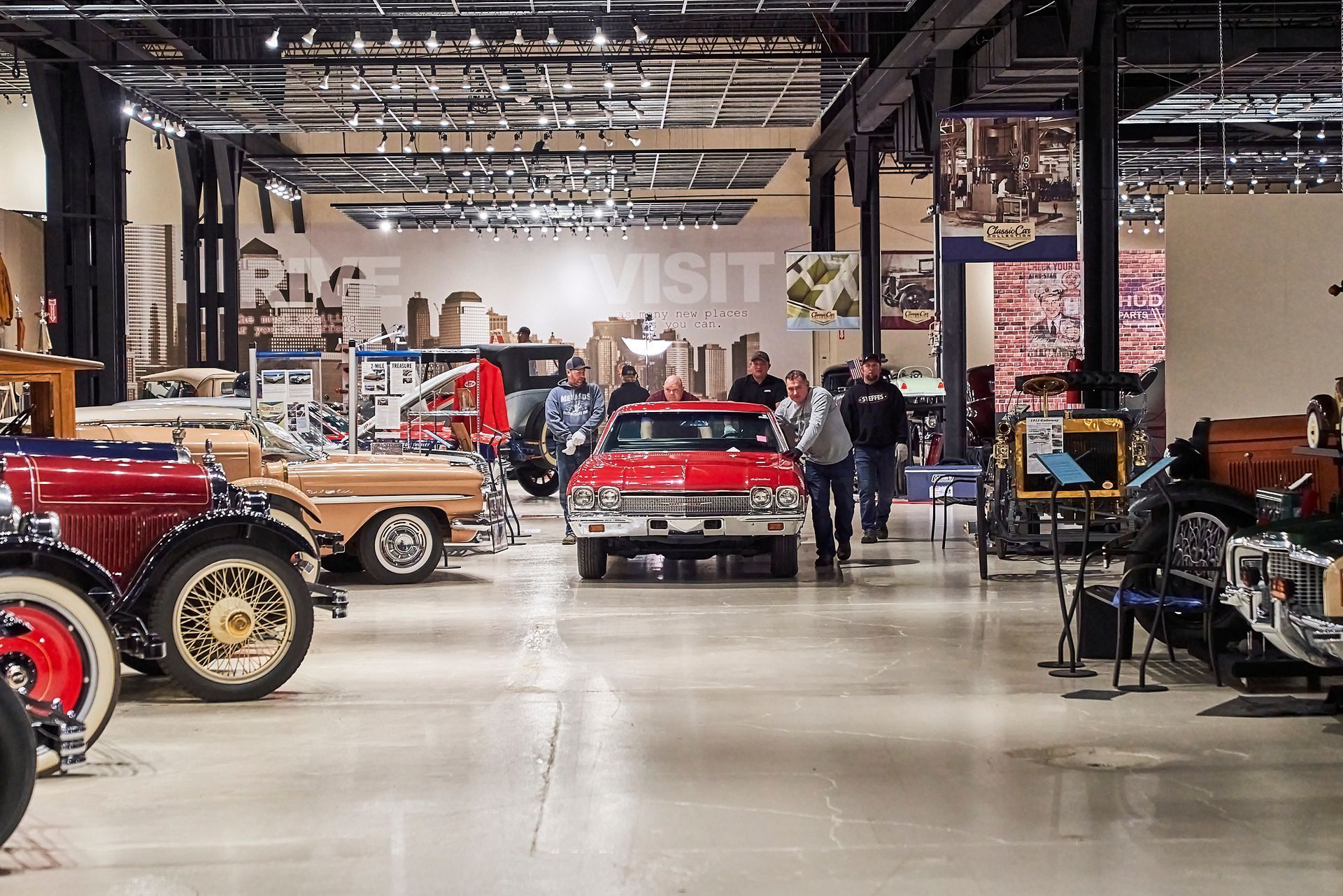 A museum filled with lots of old cars and people.