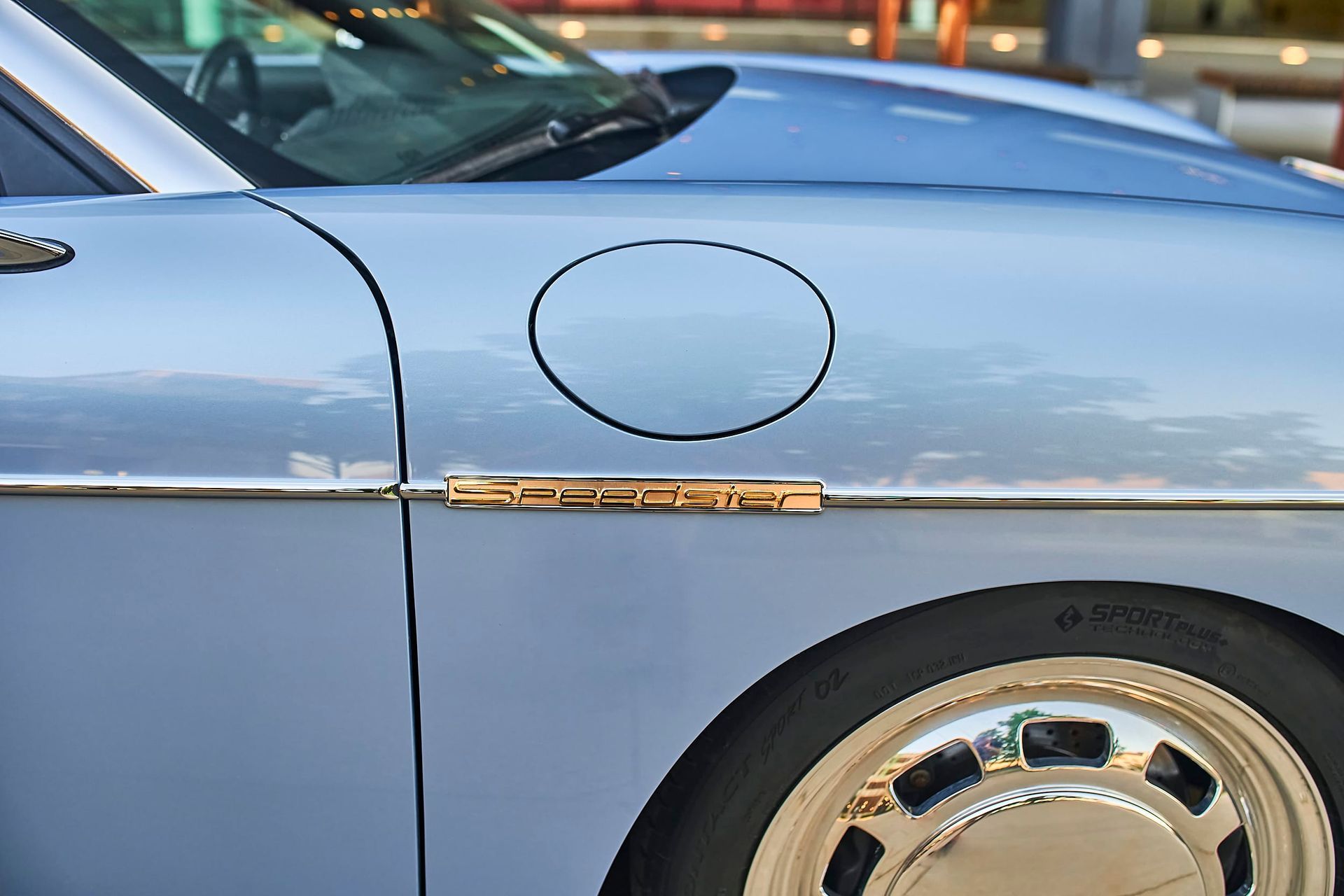 Close-up of a light blue Porsche Speedster with a chrome wheel and