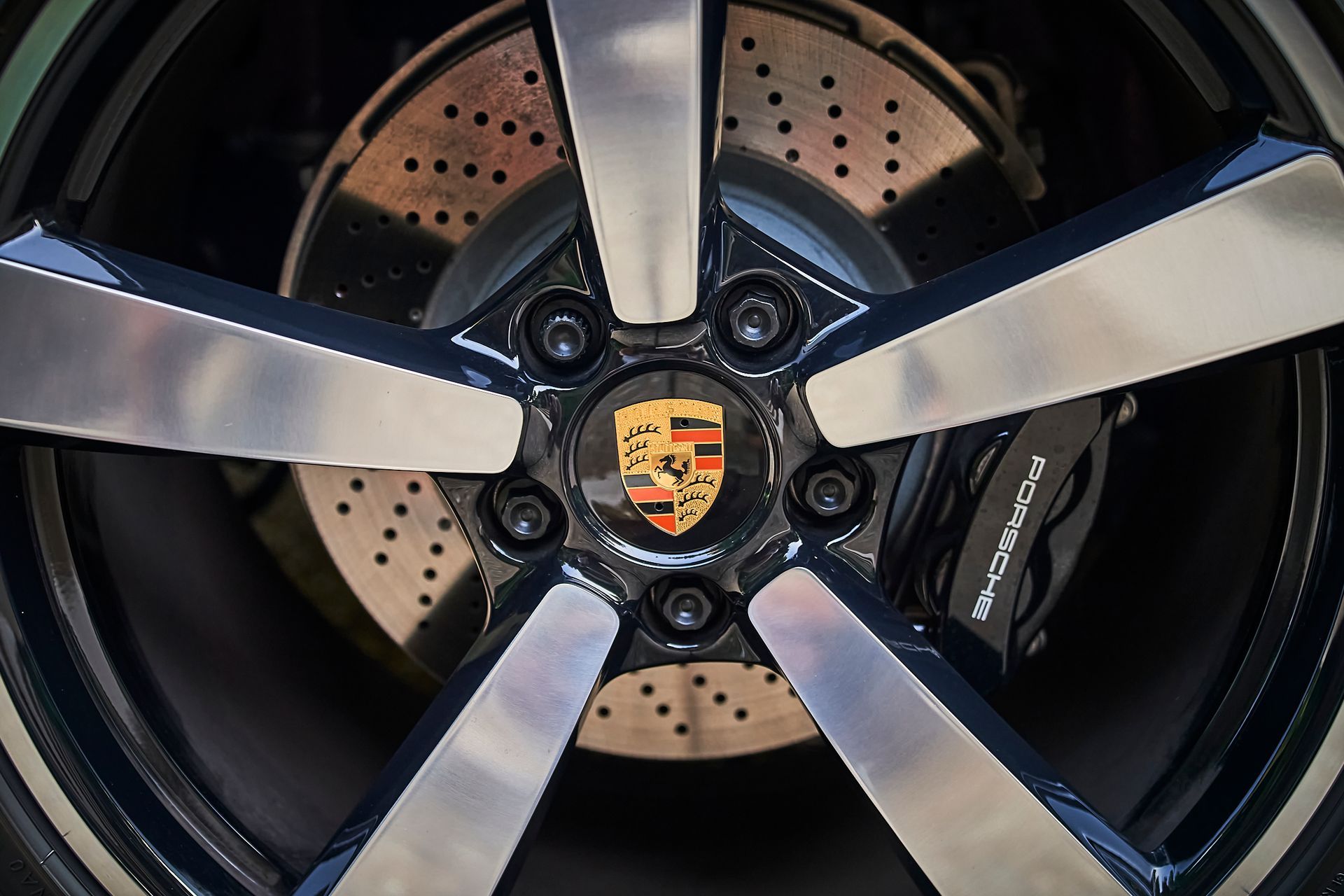 A close up of a porsche wheel with a brake disc