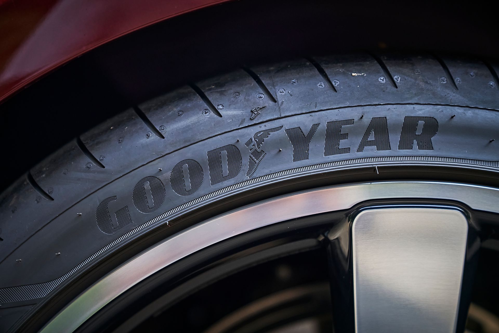 A close up of a goodyear tire on a car wheel