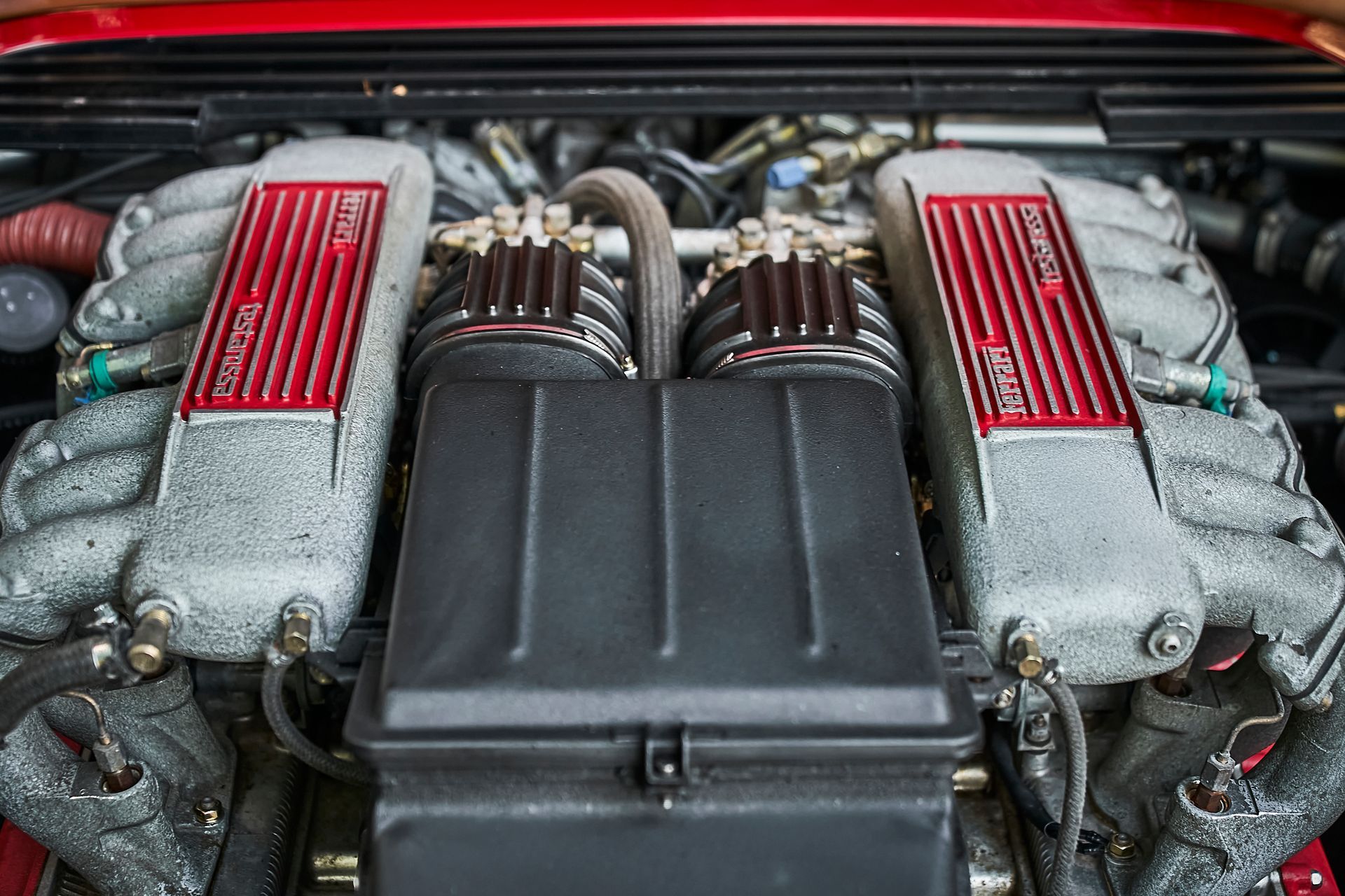 A close up of the engine of a red car.