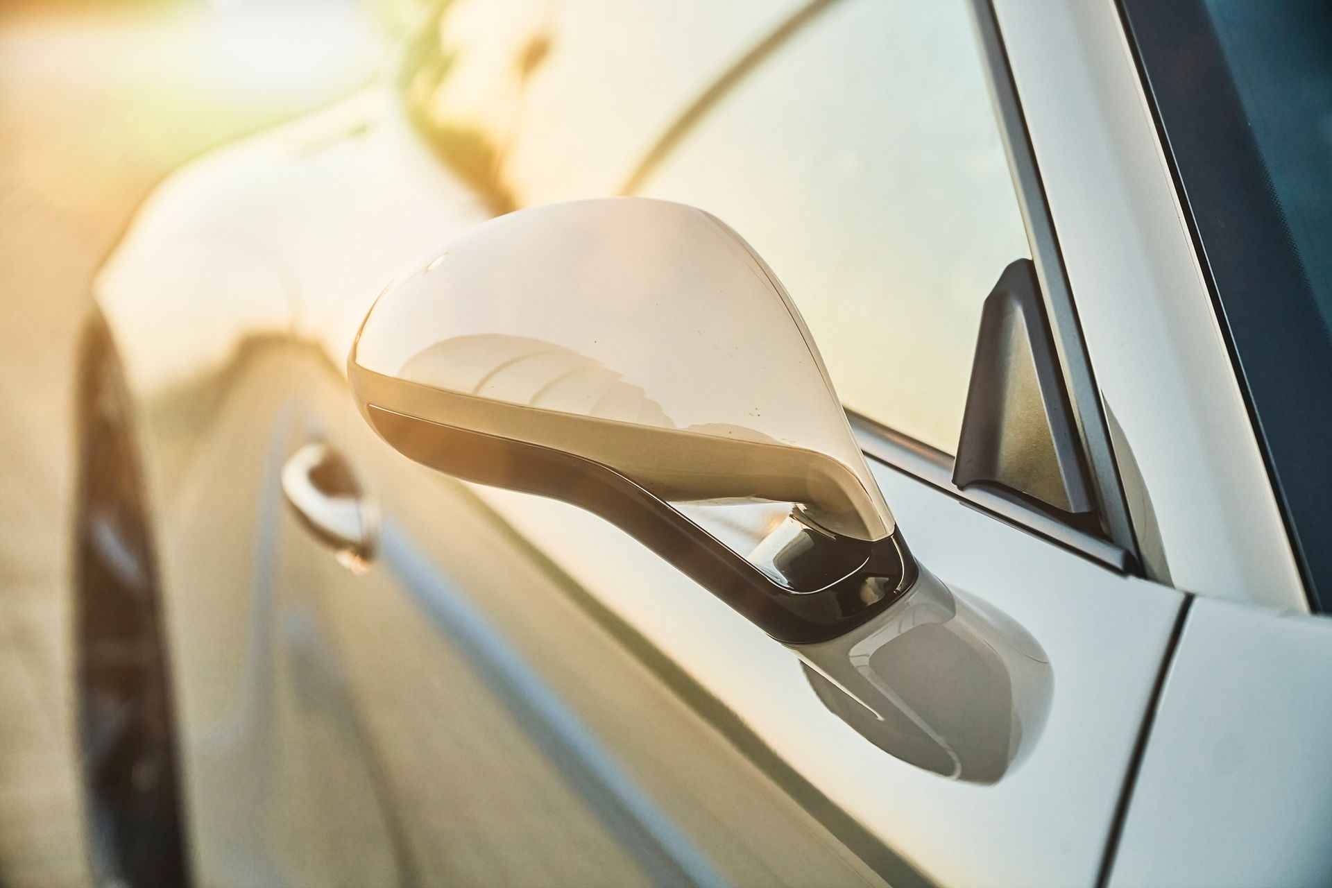 A close up of a car 's side mirror on a sunny day.