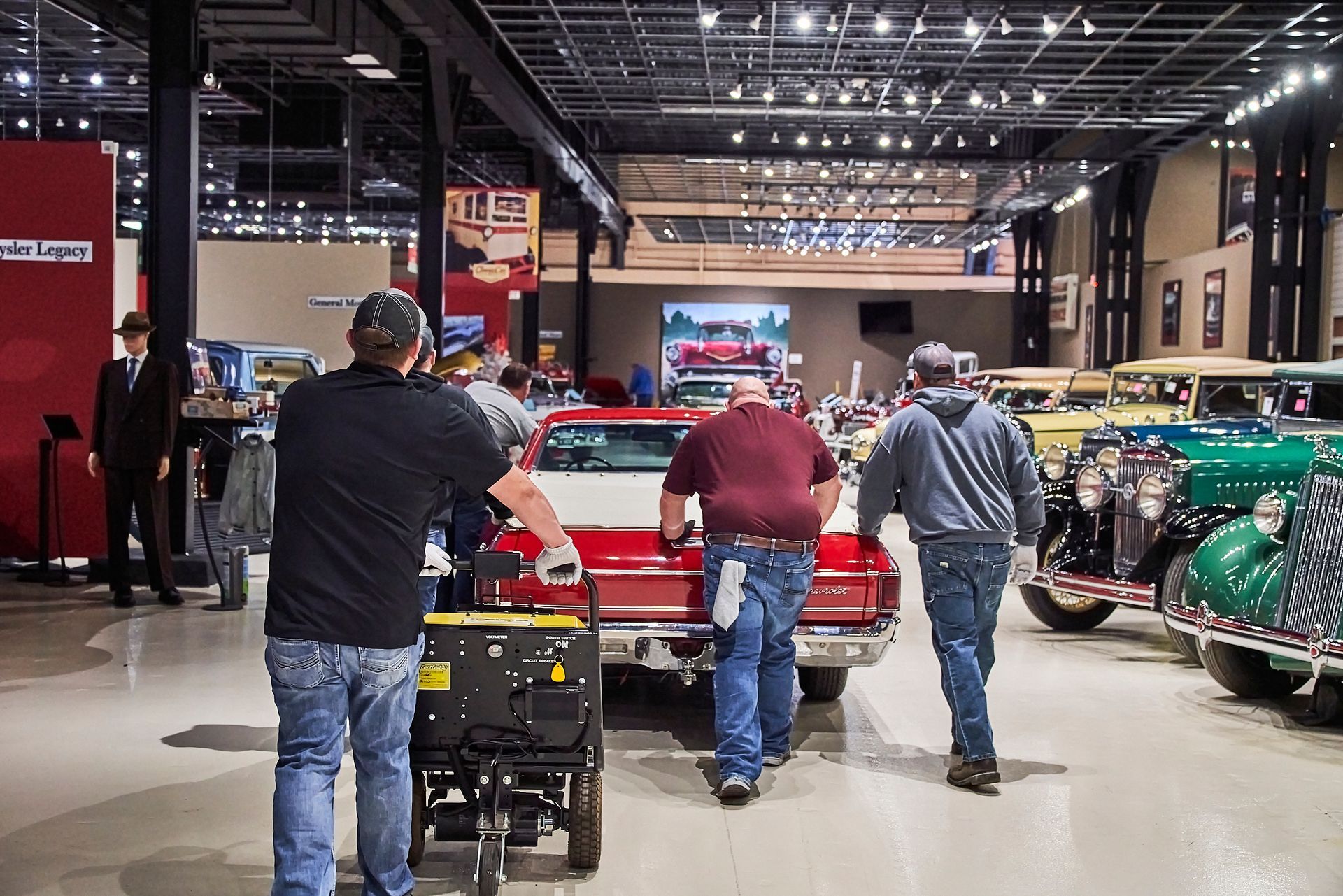 A group of men are working on a red truck in a garage
