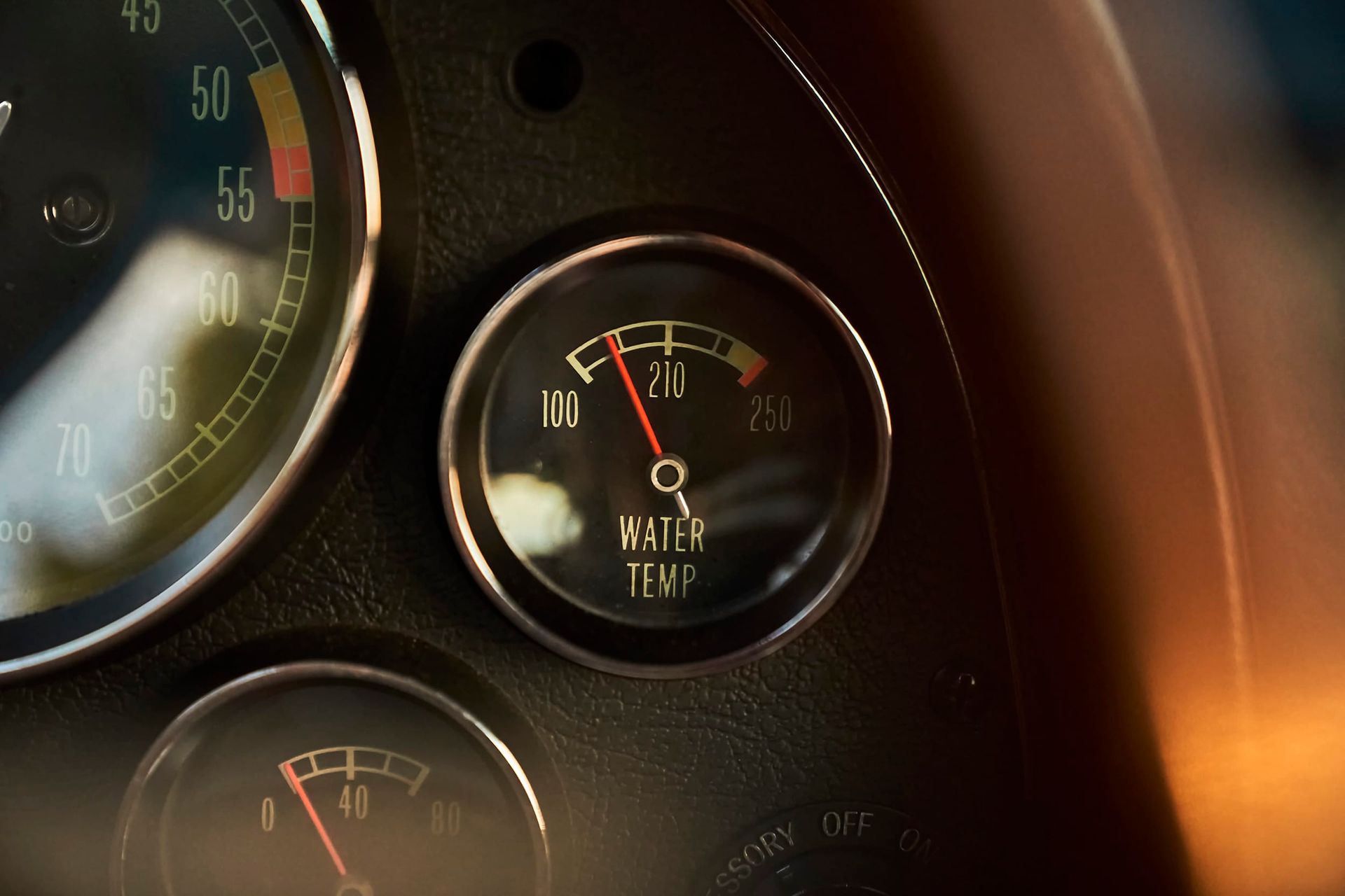 Close-up of a vintage car dashboard. The water temperature gauge reads slightly above 100 degrees.