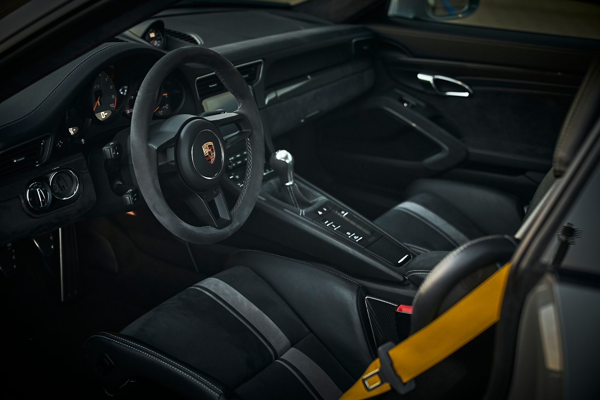 The interior of a porsche 911 gt3 rs with a yellow seat belt
