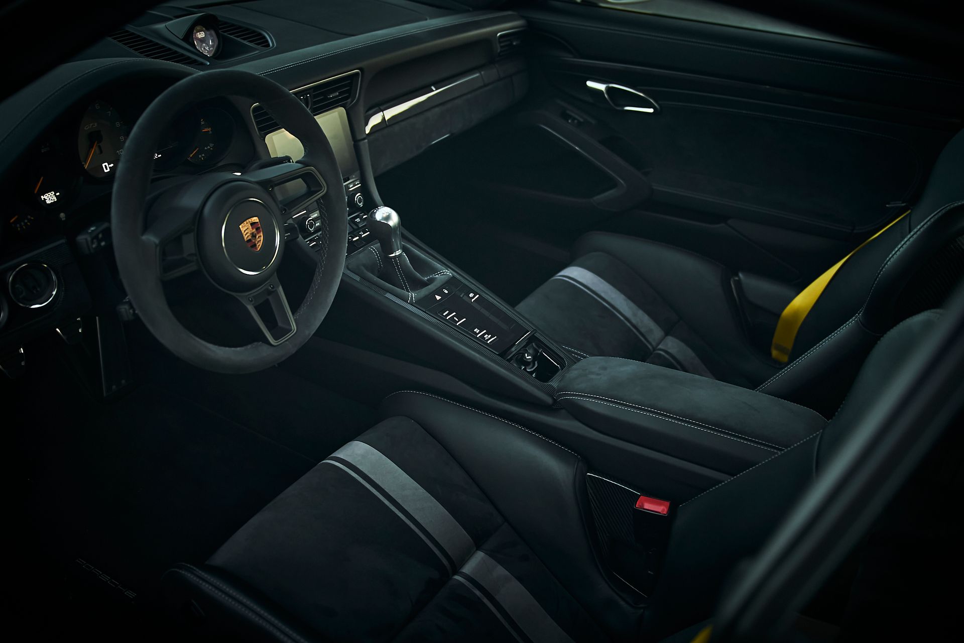 The interior of a porsche 911 with black and yellow seats