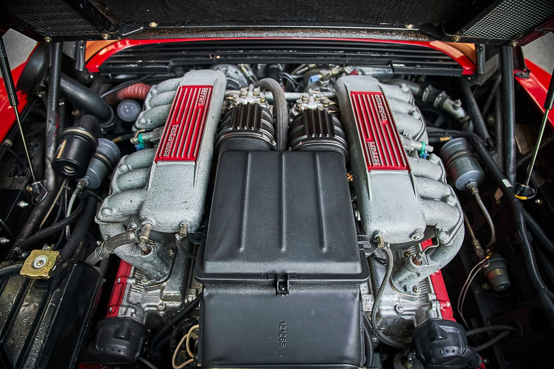 A close up of a car engine with the hood open
