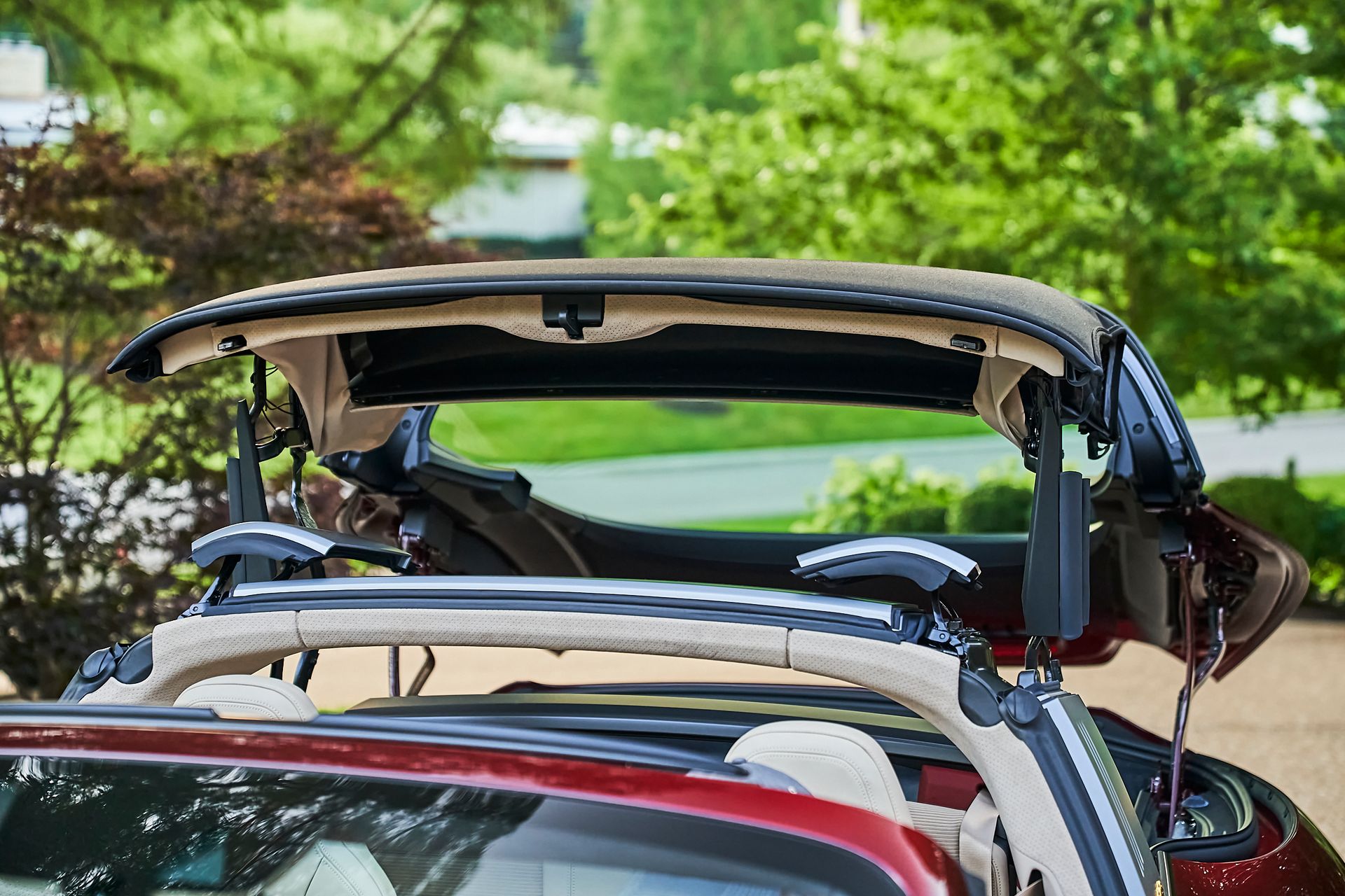The roof of a red convertible car is open.