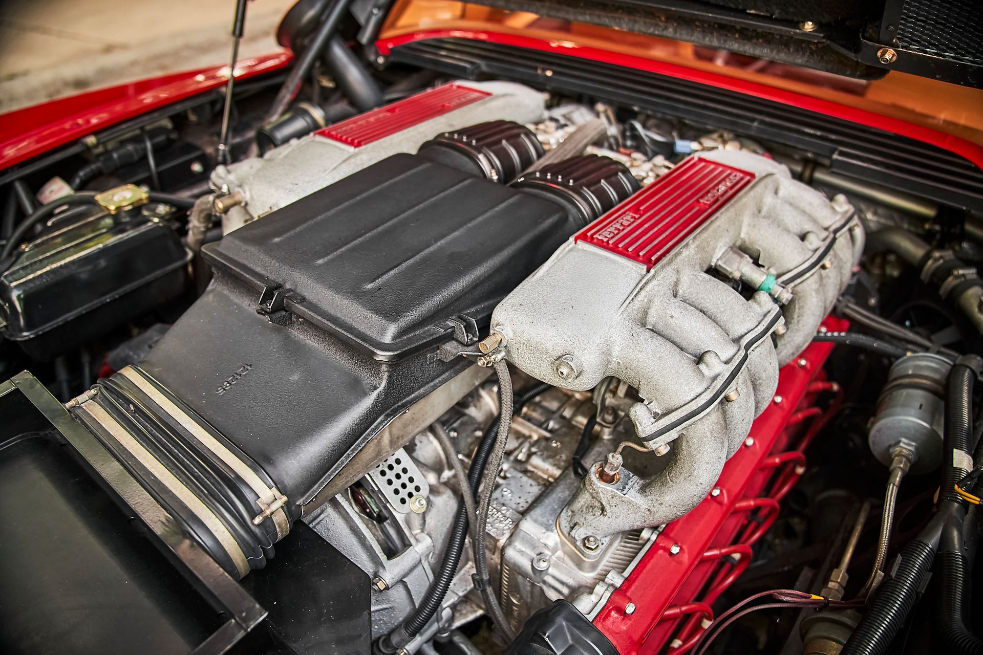 A close up of a car engine with the hood up.