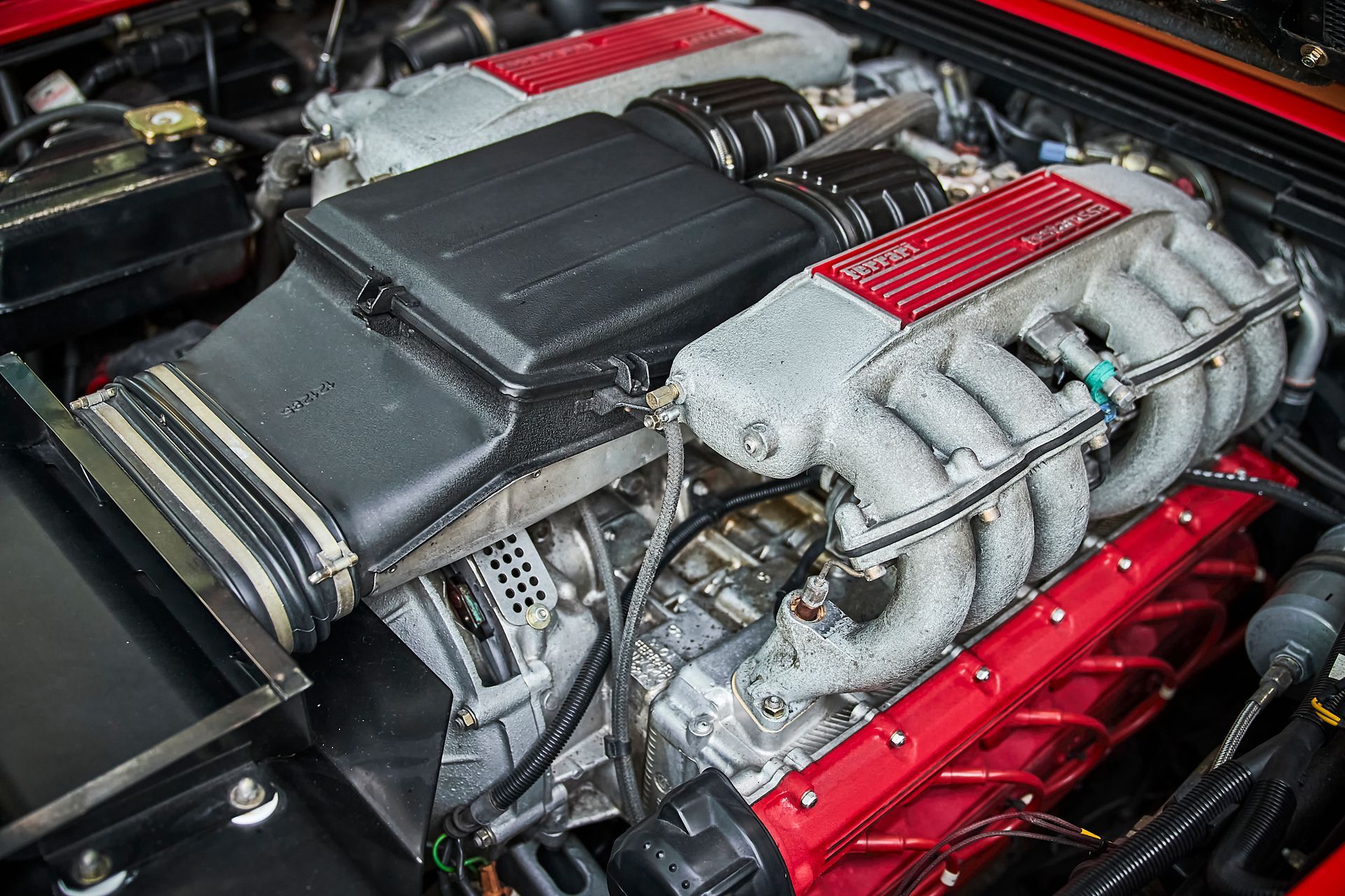A close up of the engine of a red car.