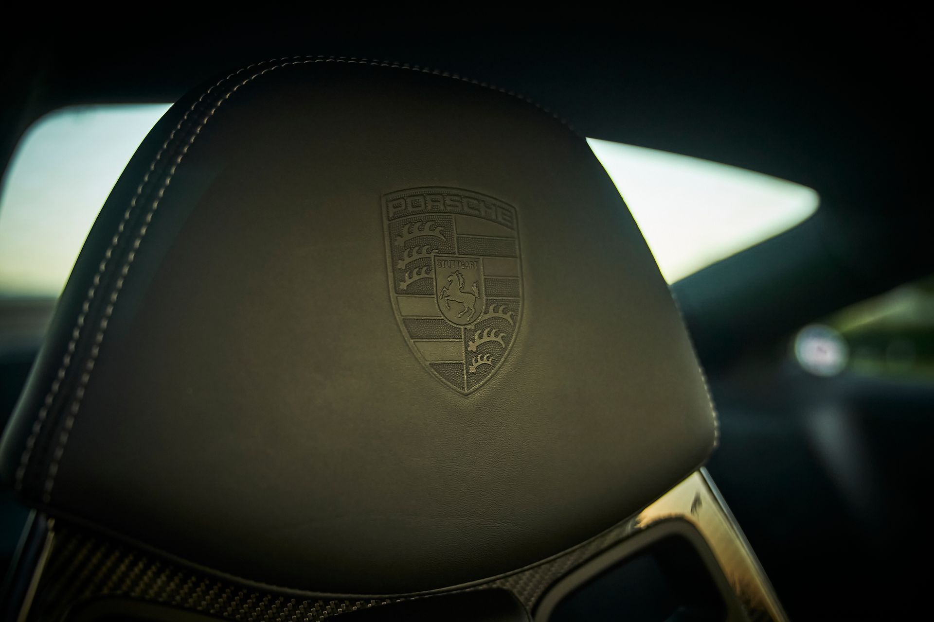 A close up of a car seat with a porsche logo on it.