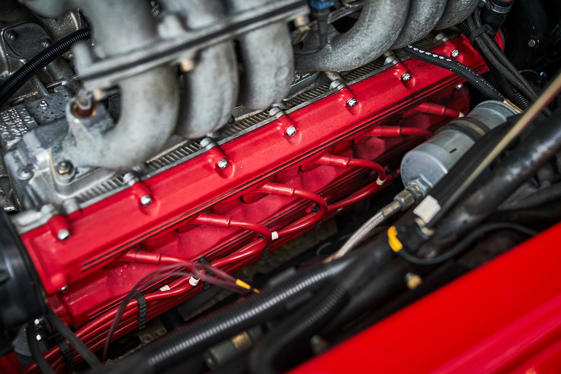 A close up of a red engine in a car.