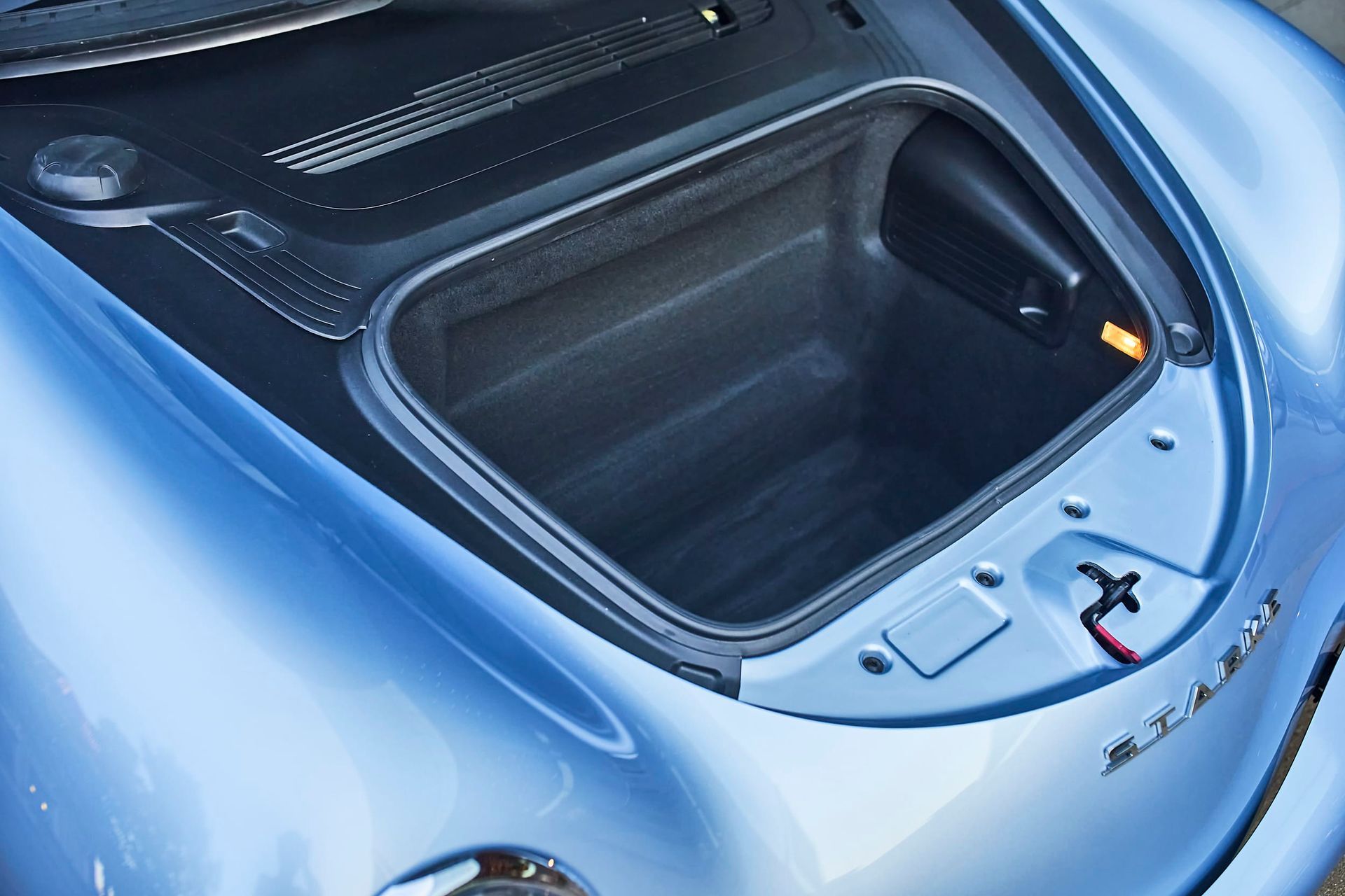 Blue car's front trunk (frunk) open, revealing an empty storage compartment.