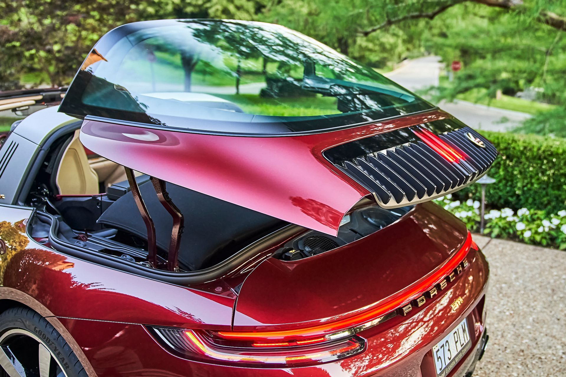 The hood of a red porsche targa is open.