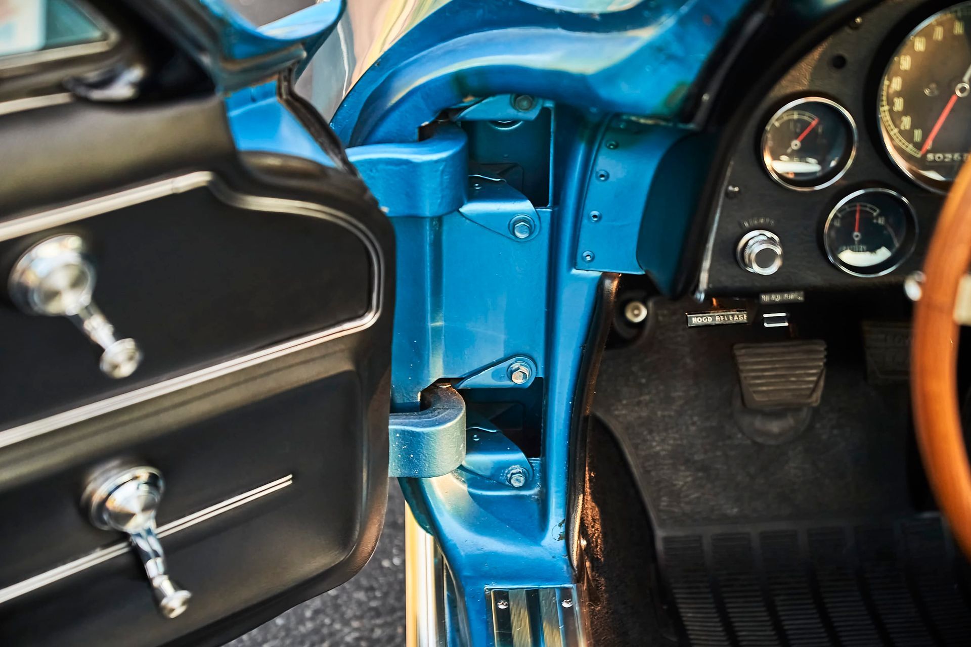 Blue classic car interior with open door. Door panel and dashboard visible.