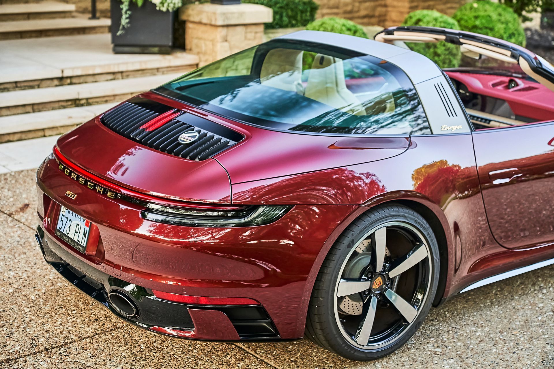 A red porsche targa is parked in front of a house.