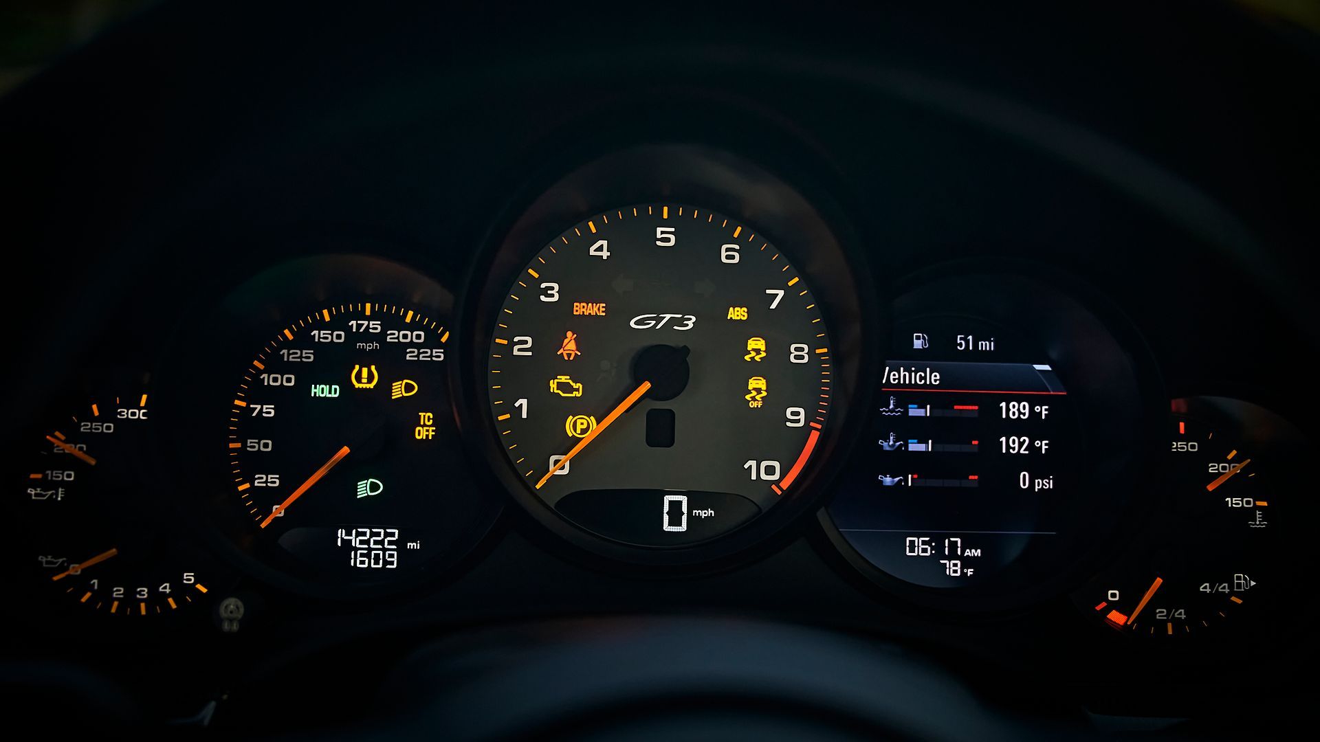 A close up of a car dashboard with a speedometer and a tachometer