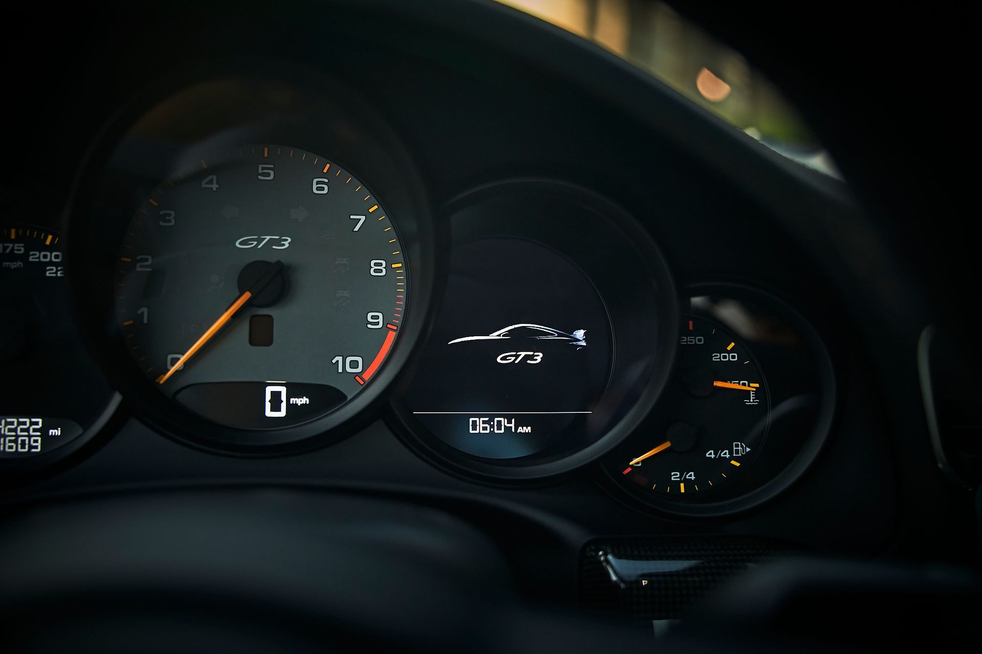 A close up of a car dashboard with a speedometer and a tachometer