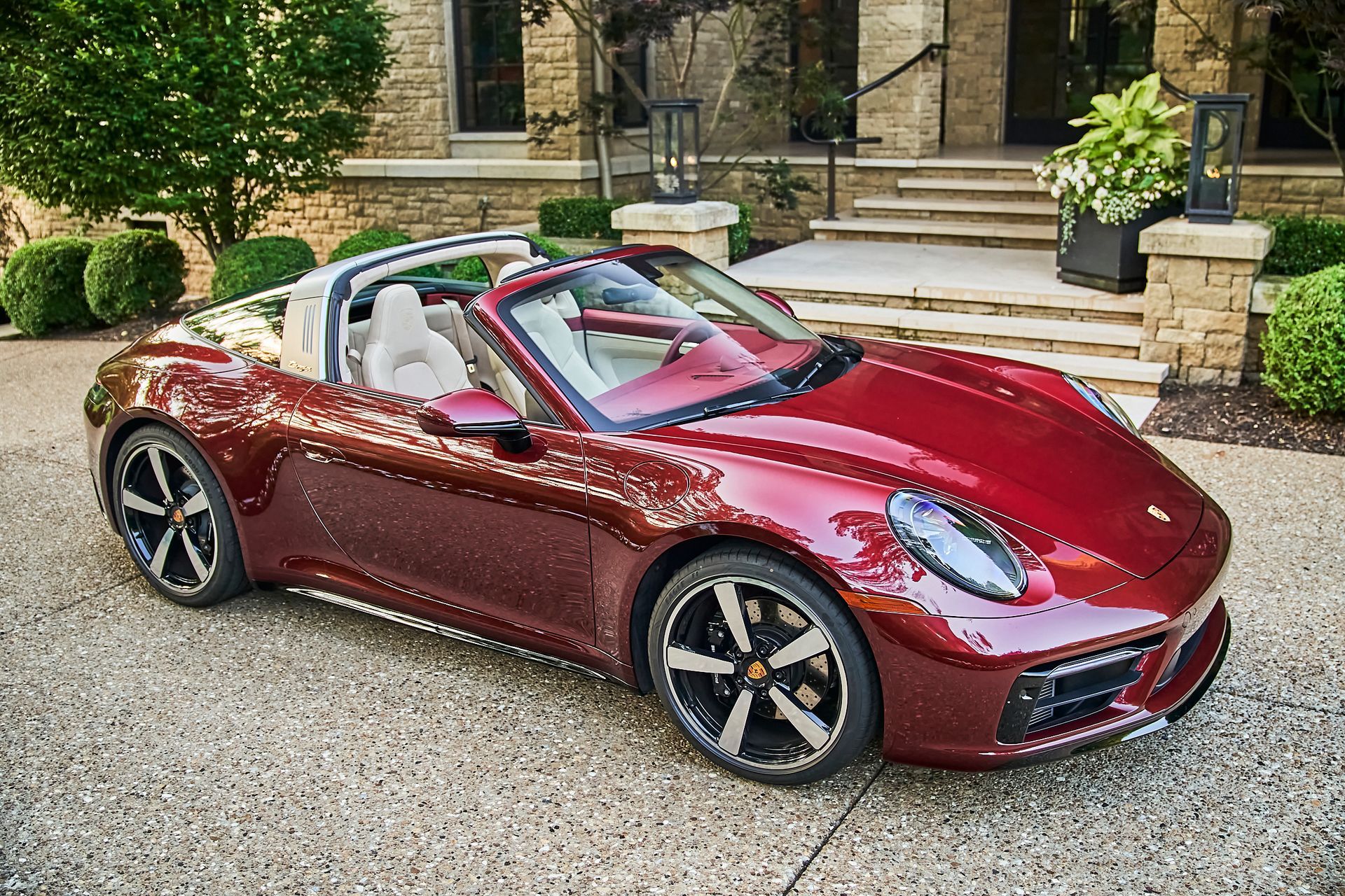 A red porsche targa is parked in front of a house.
