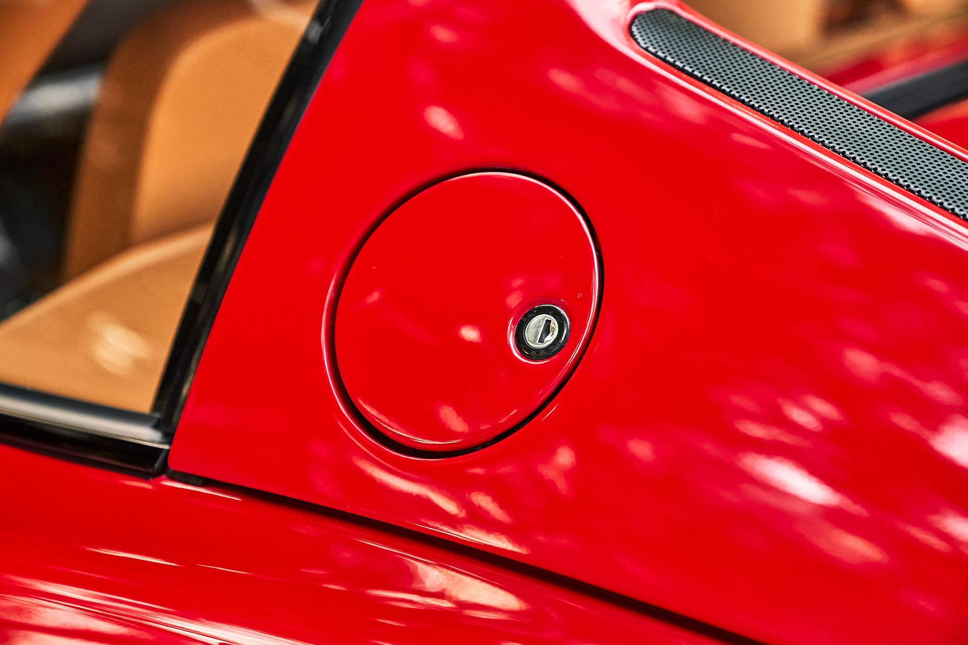 A close up of a red car with a fuel cap