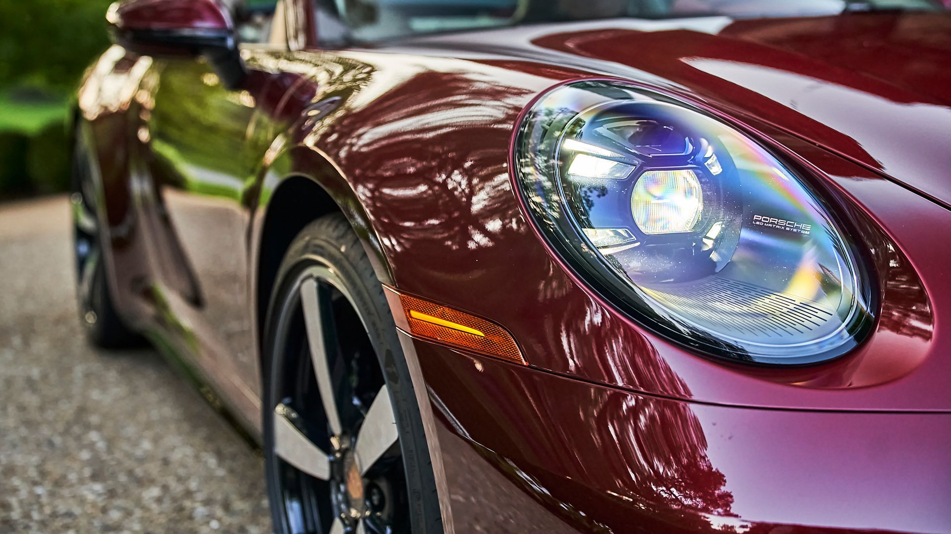A close up of a red sports car parked on the side of the road.