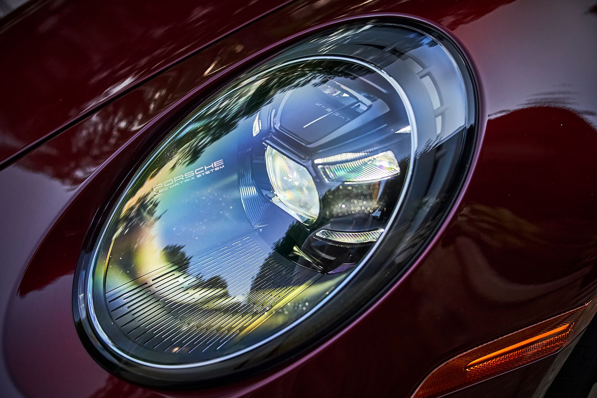 A close up of the headlight of a red car.