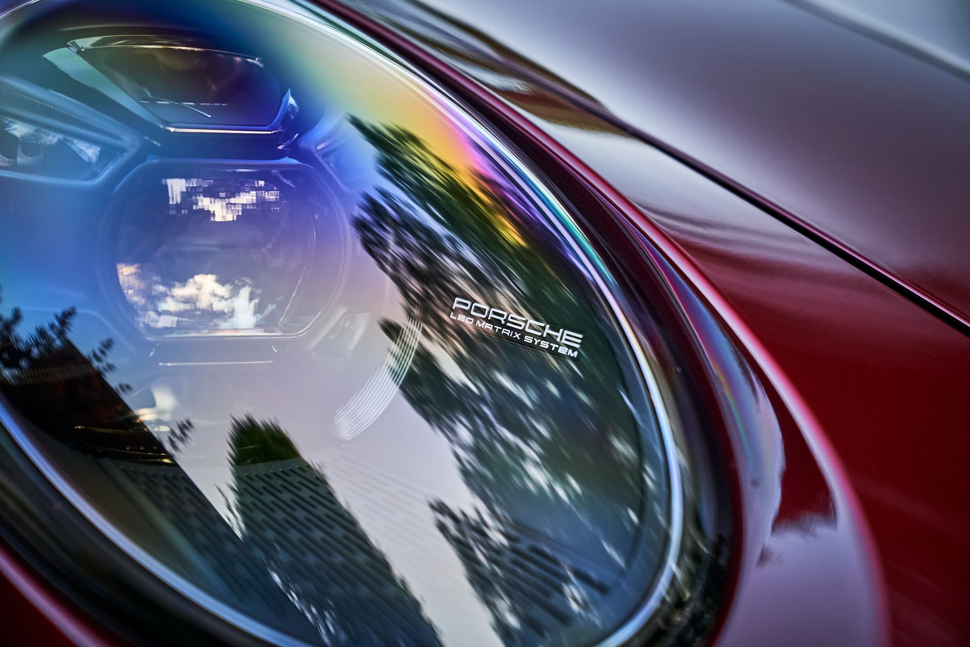 A close up of the headlight of a red car