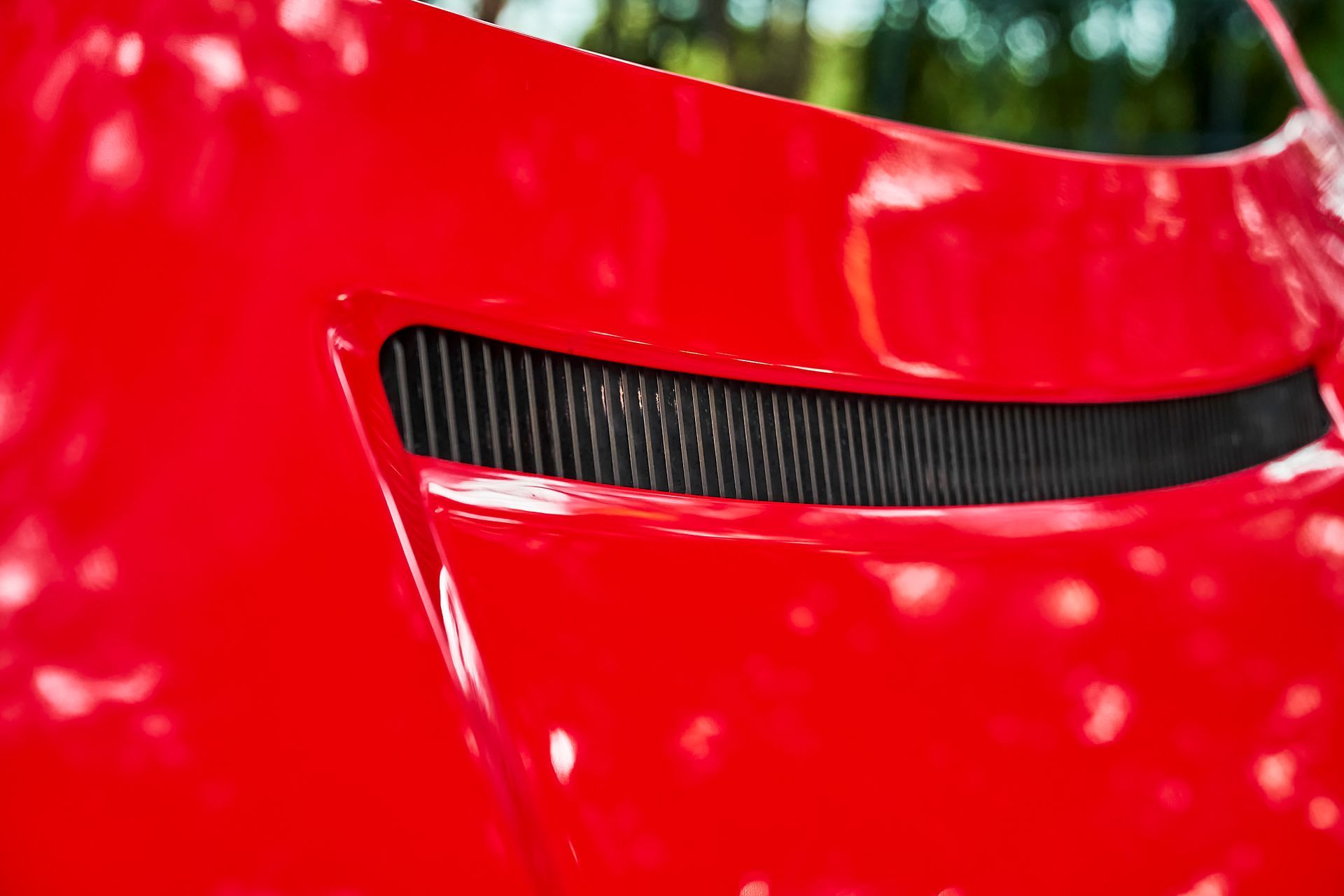 A close up of the hood of a red car.