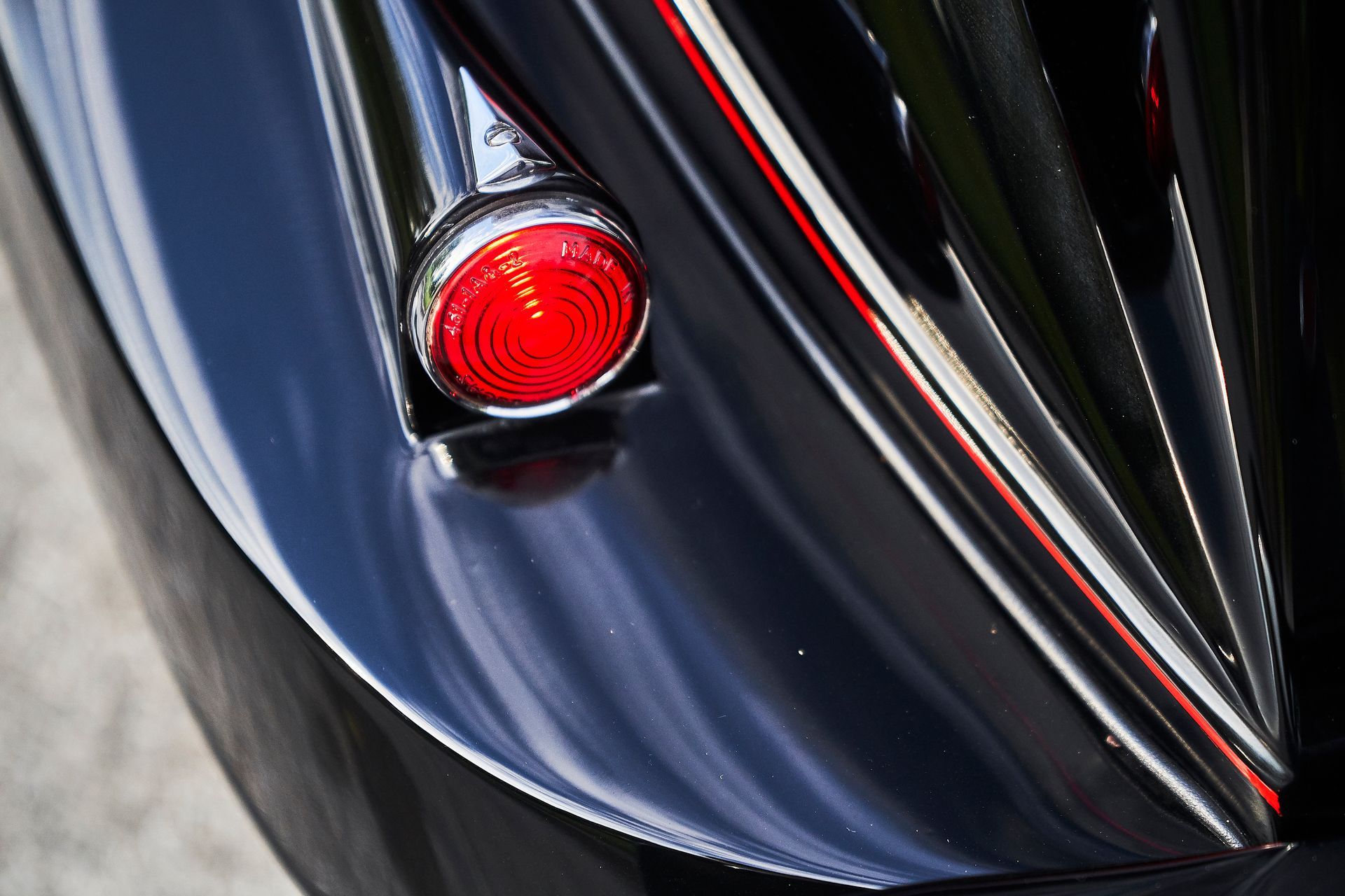 A close up of a red tail light on a black car