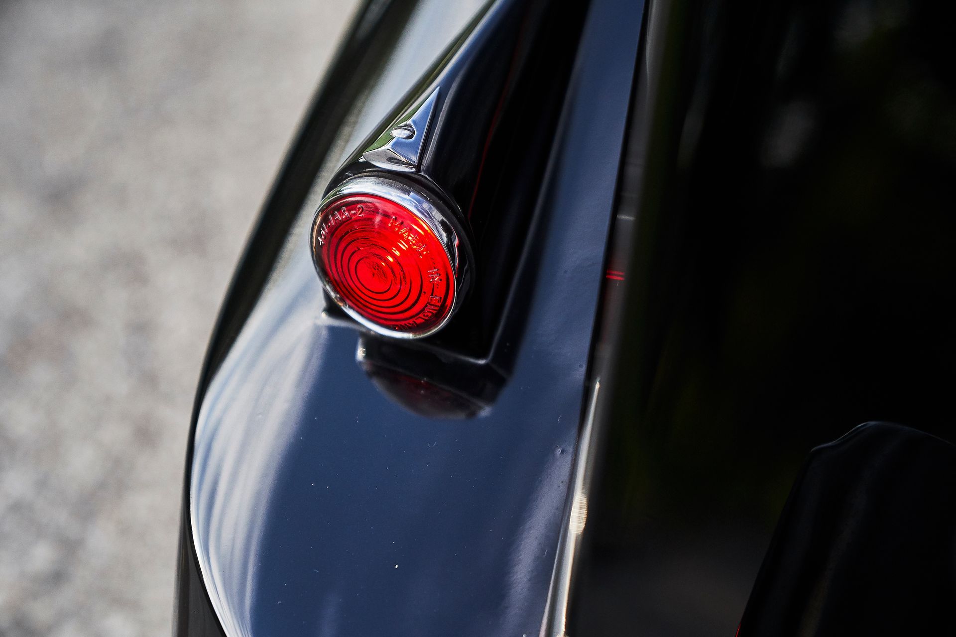 A close up of a red tail light on a black car.
