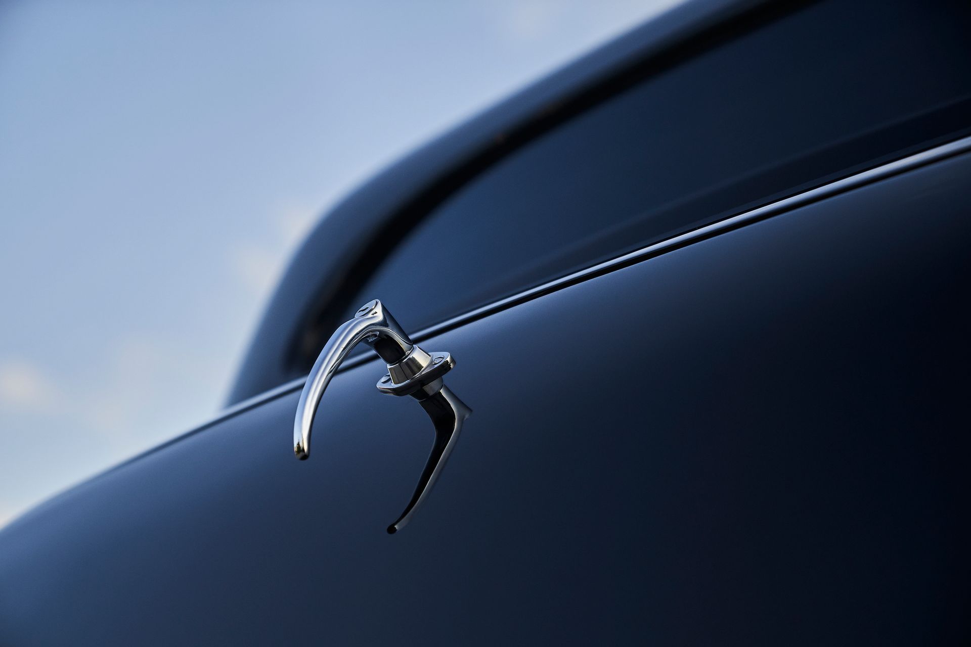 A close up of a car door handle on a blue car