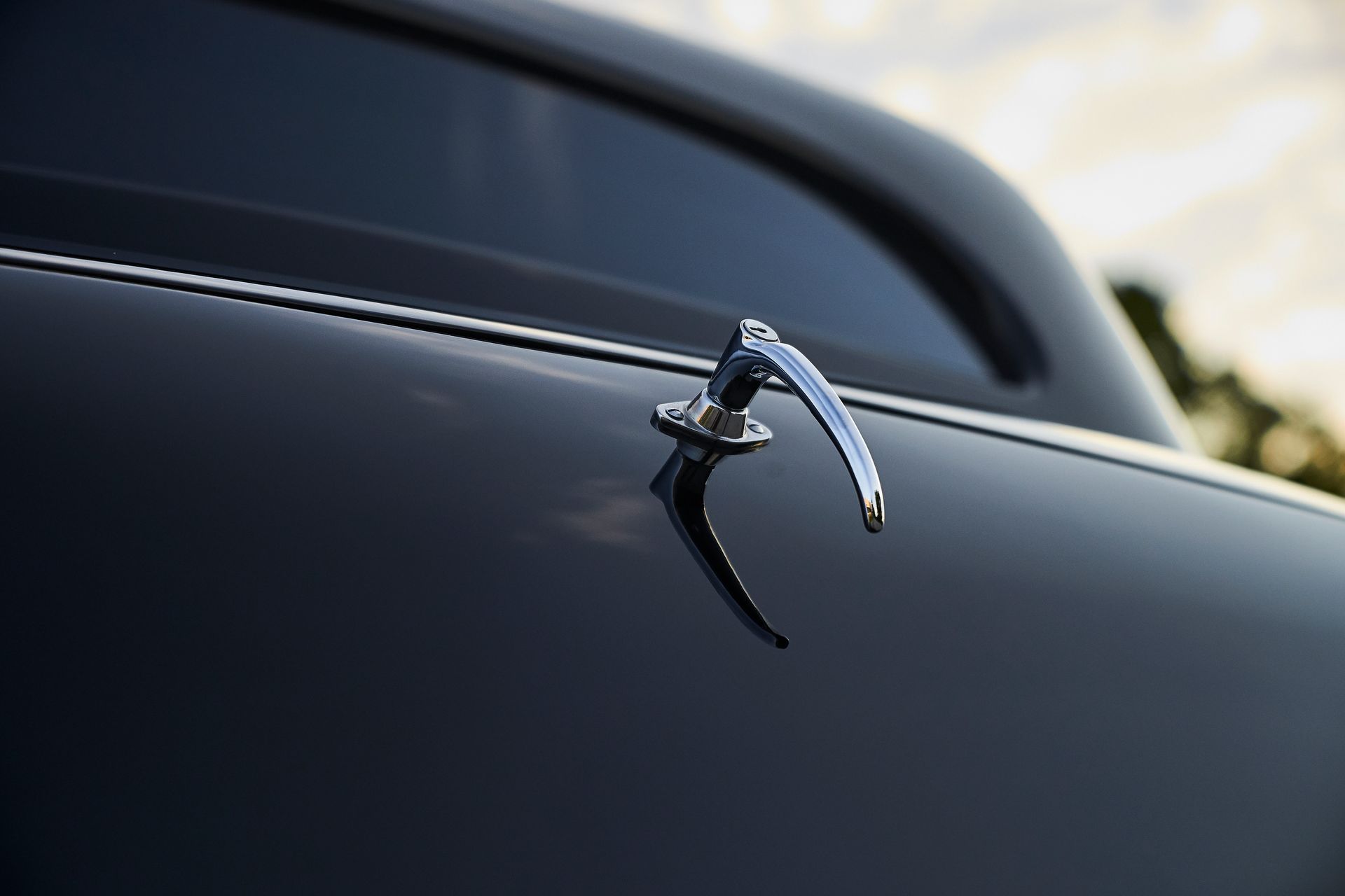 A close up of a car door handle on a black car