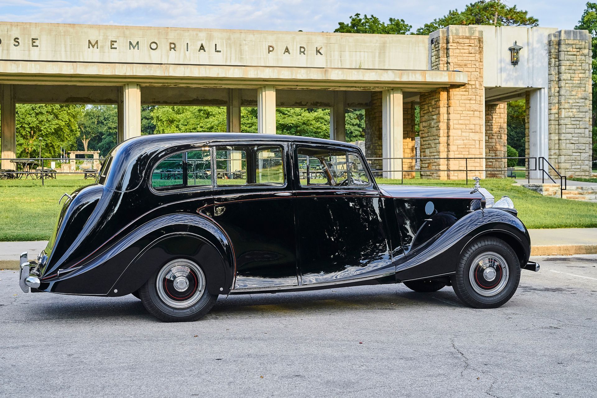 A black car is parked in front of a building that says memorial park