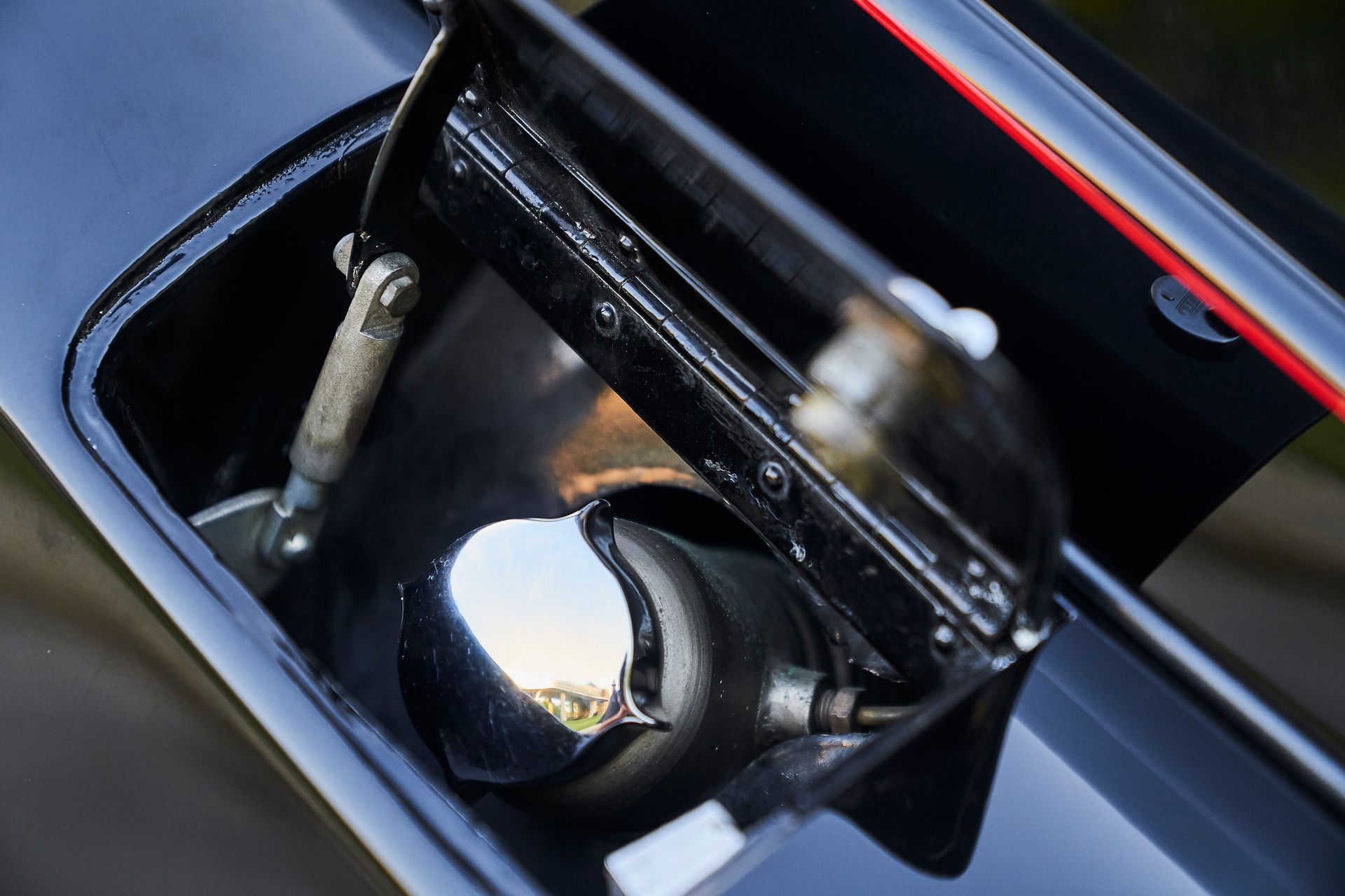 A close up of a car 's fuel tank with the lid open