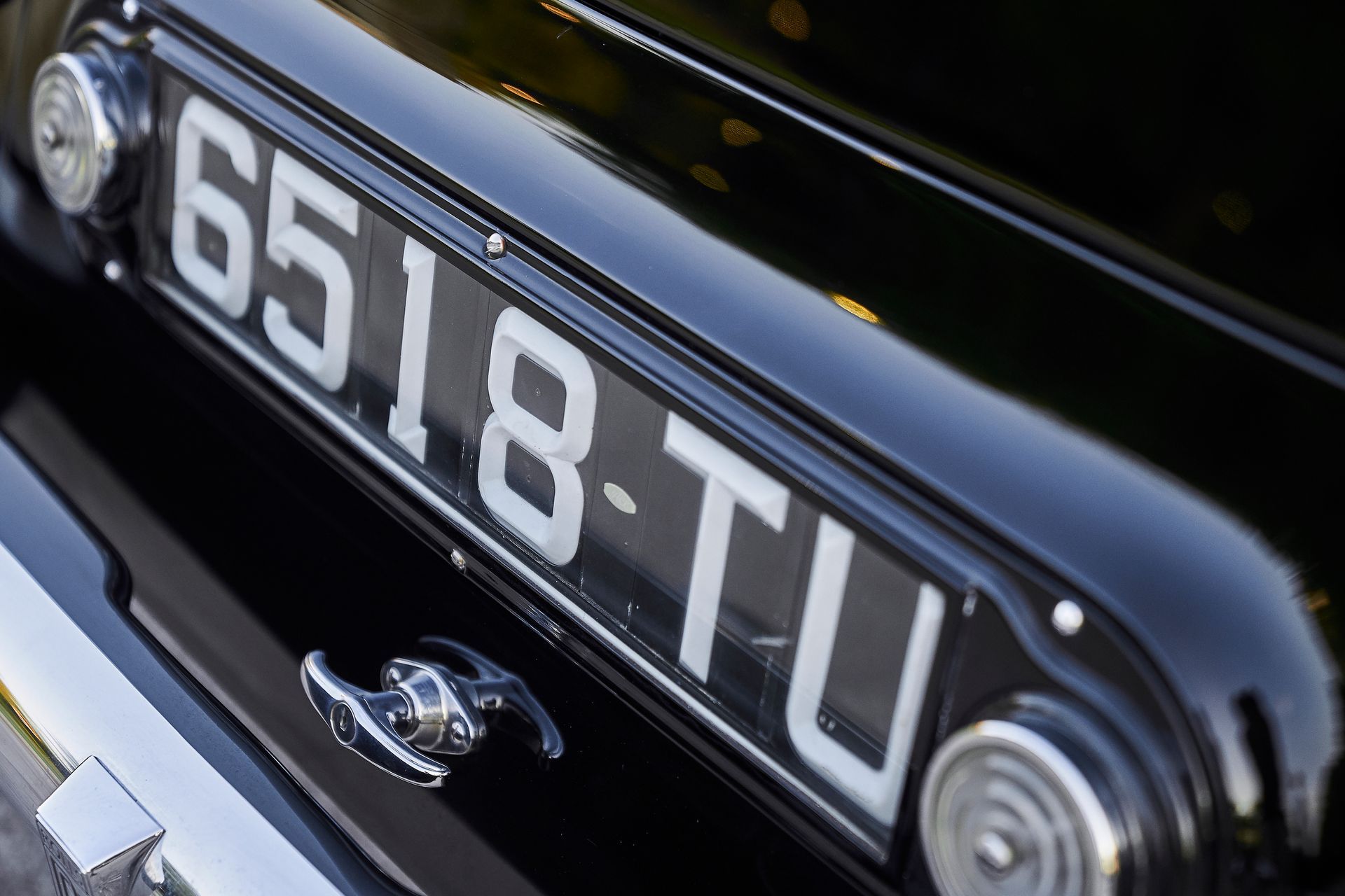 A black car with a license plate that says 6518 tu