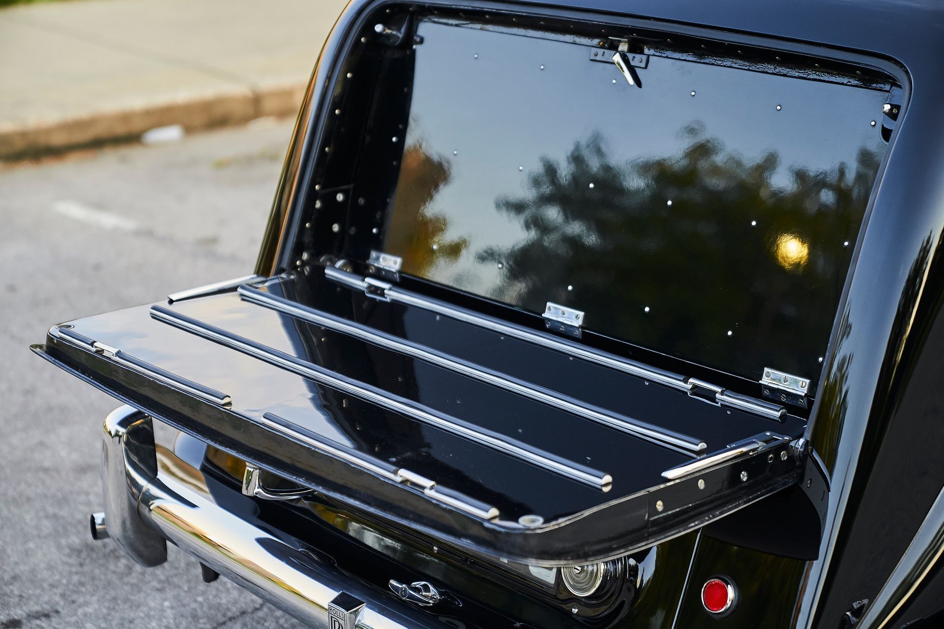 The back of a black car with the trunk open.