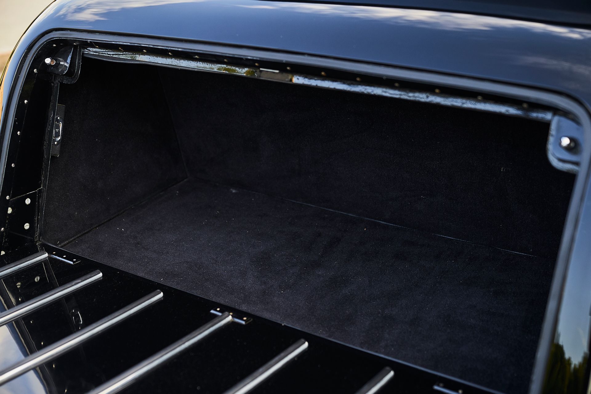The back of a black car with a trunk open