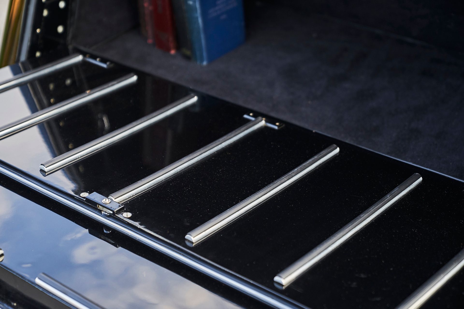 The trunk of a black car has a row of metal bars on it