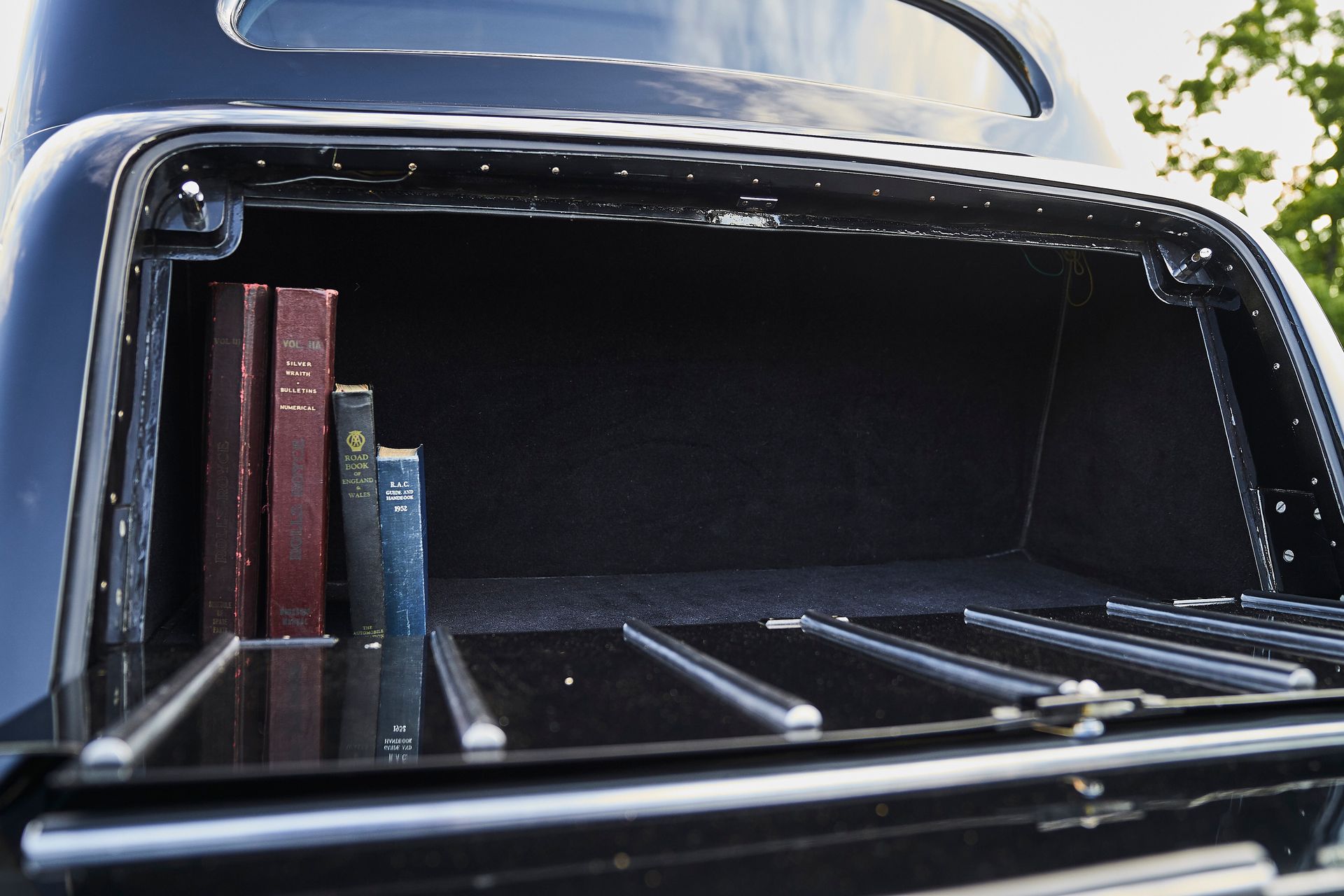 The trunk of a black car with books in it