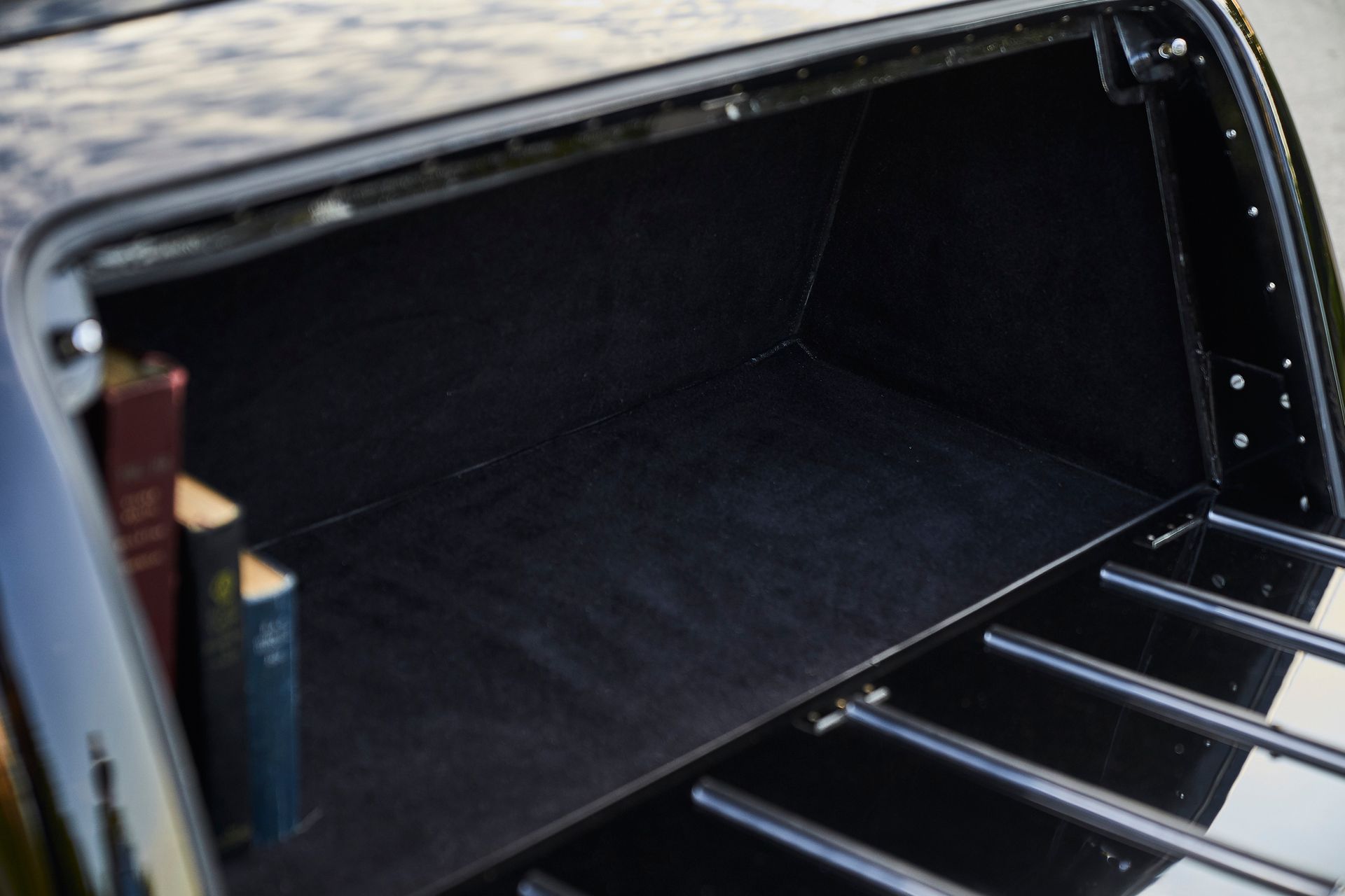 The trunk of a black car with two books in it.