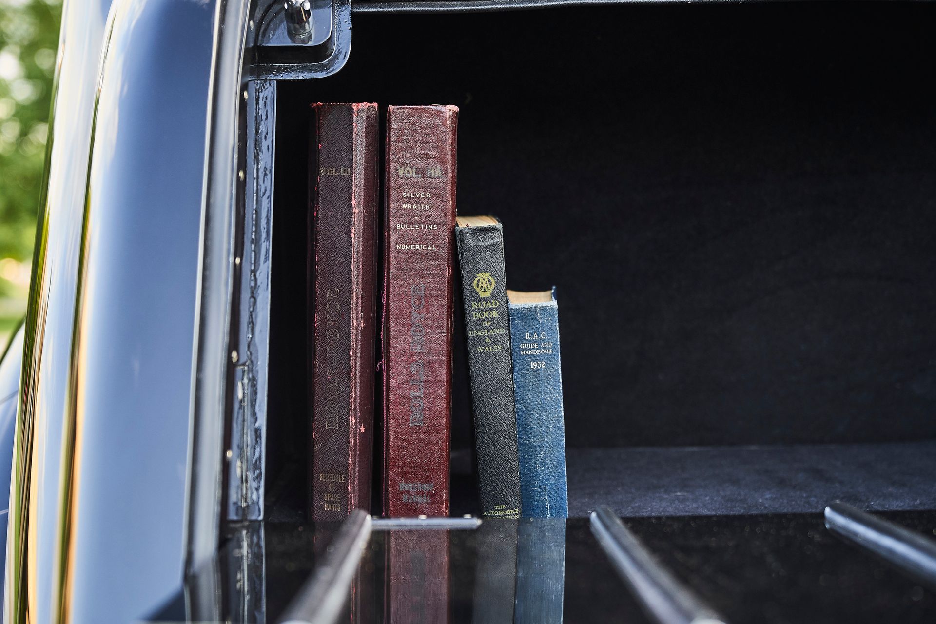 A row of books are lined up in the back of a car